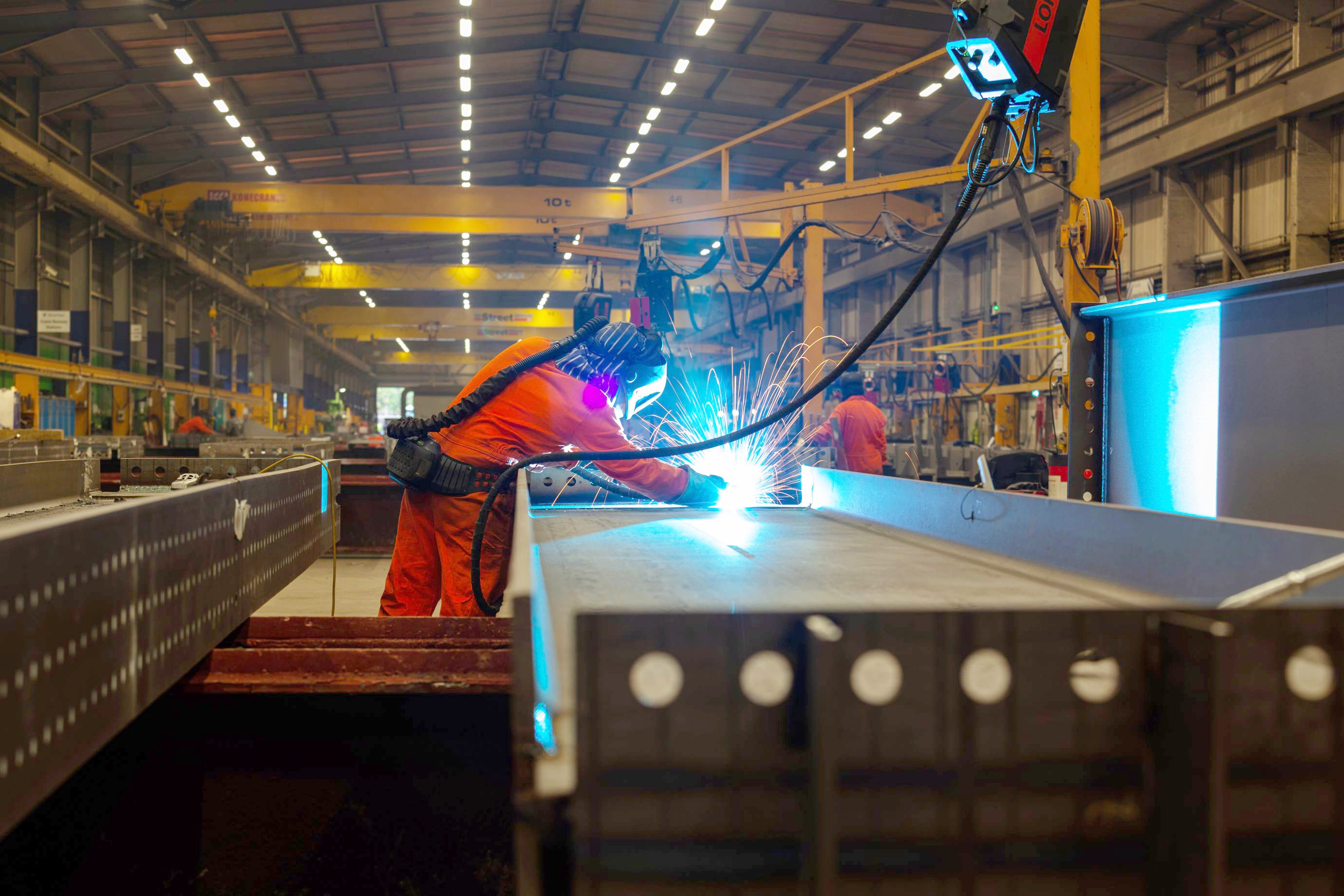 Member of staff at Severfield using a grinder on metal.