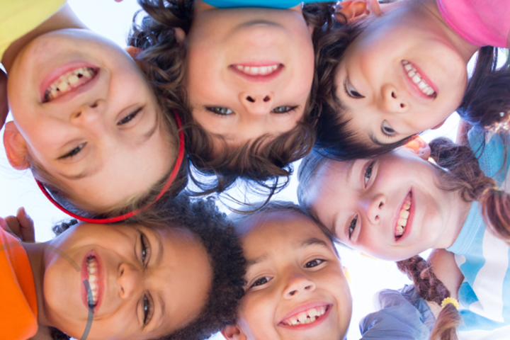 Group of children looking down smiling