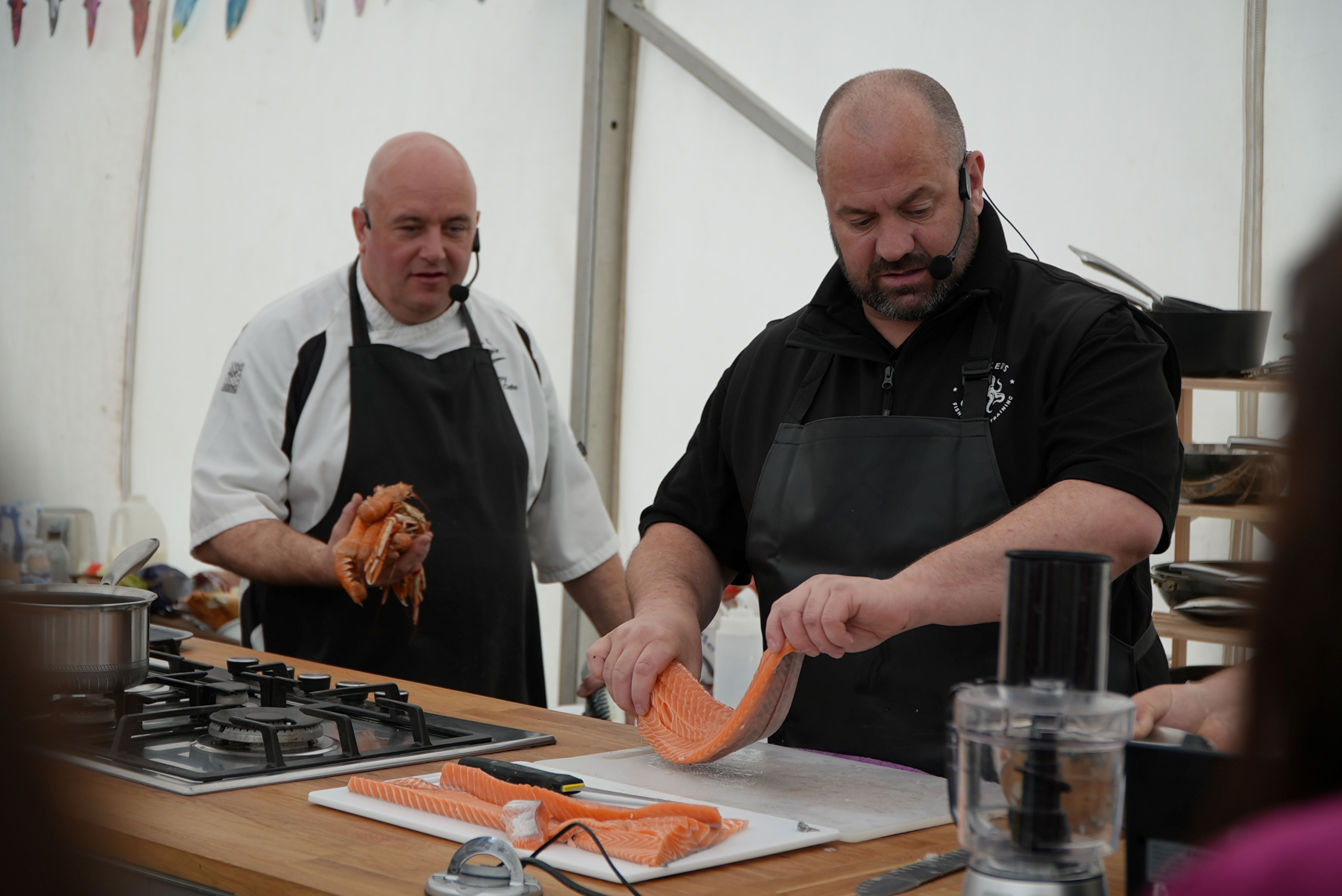 Two chefs giving a demonstration with fish
