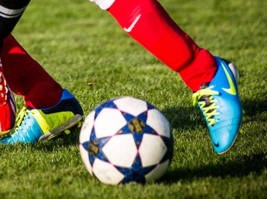 A football with the feet of a player about to kick the ball