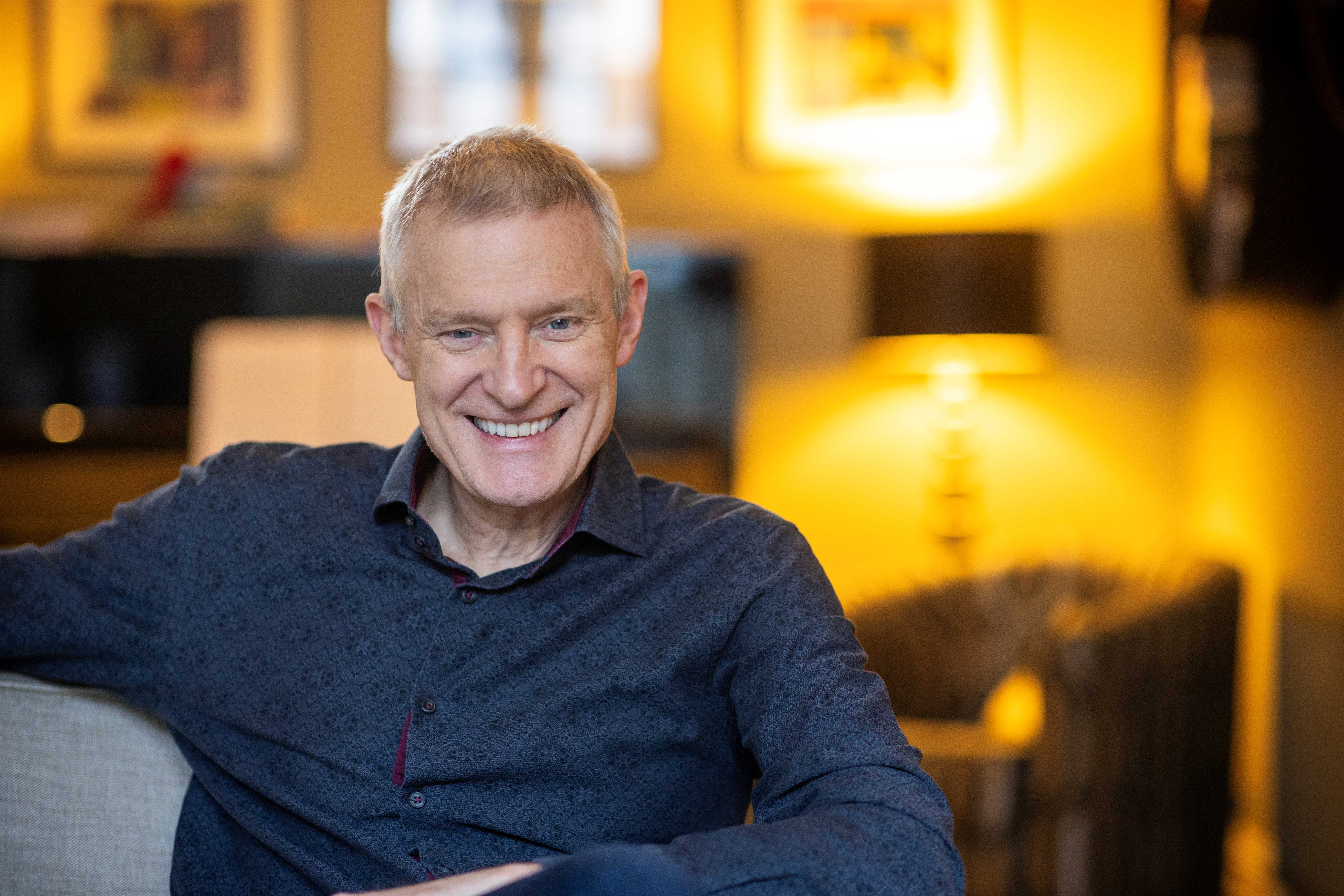 Photo of Jeremy Vine sitting in a chair smiling at the camera