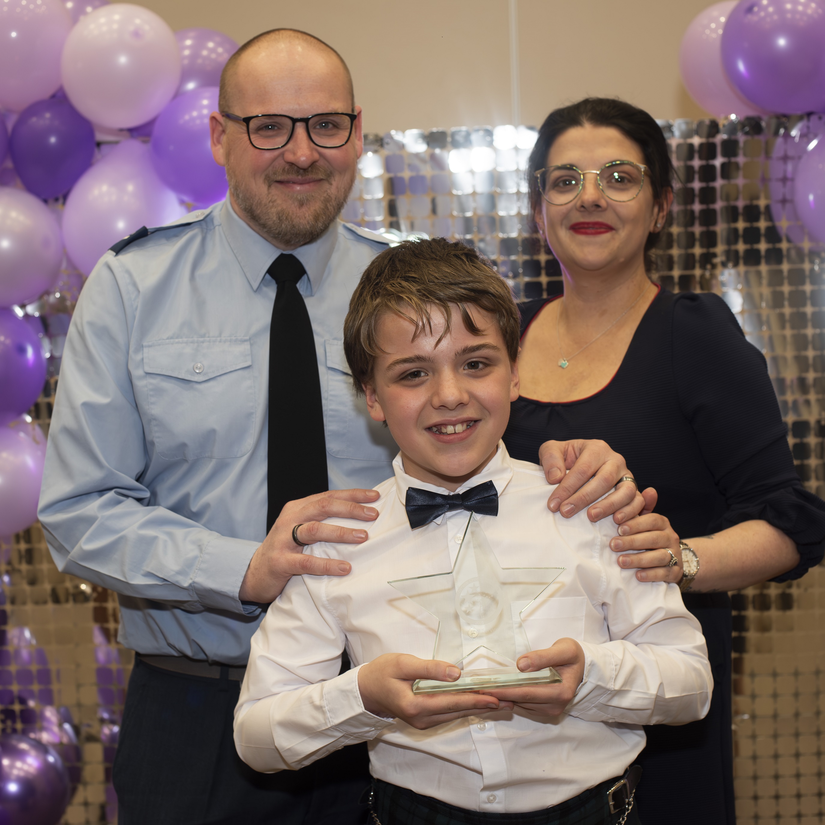 Finley holding his award with his family at the Military Awards