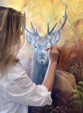 Photo of Vicky Tucker painting a deer