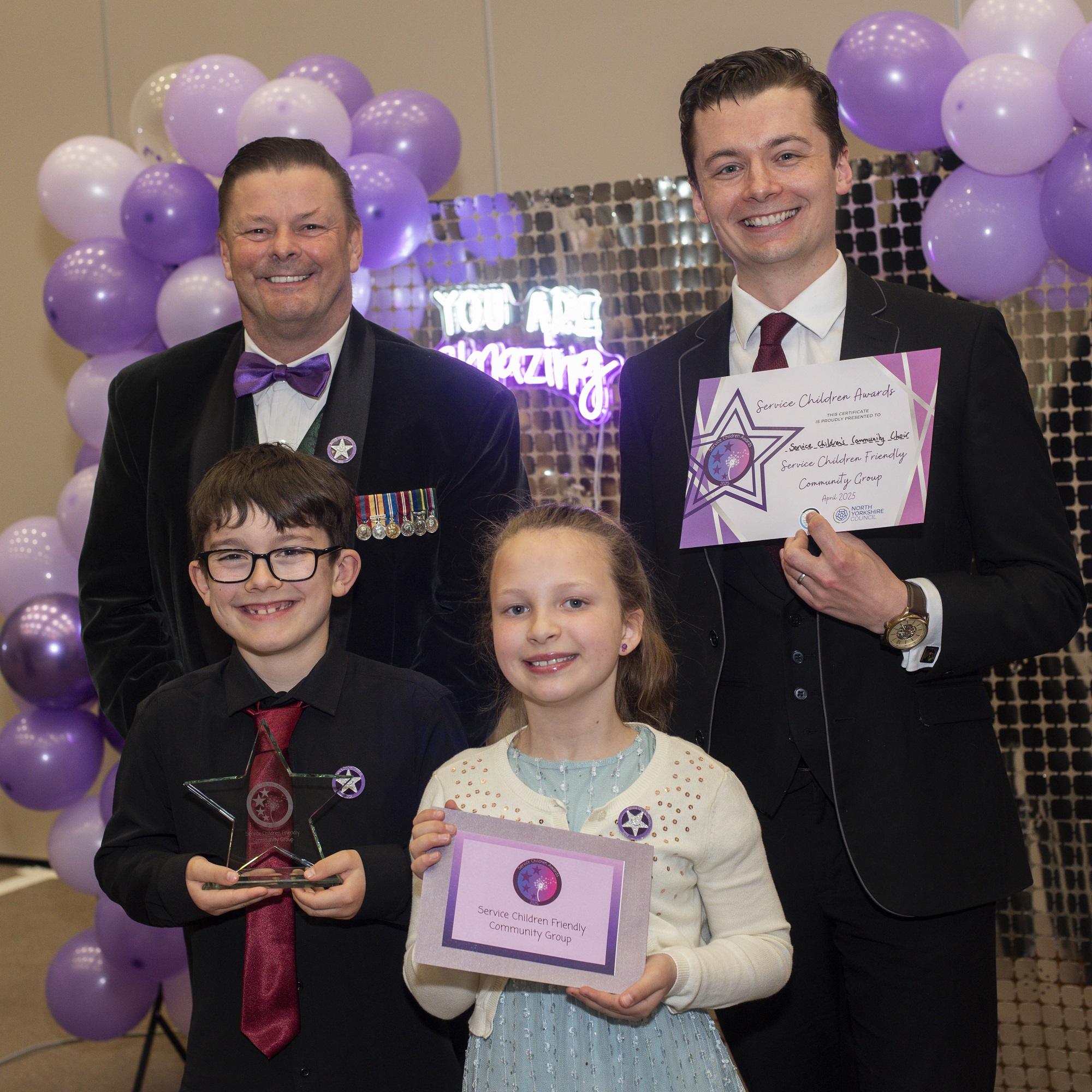 Two children and two adults with their awards