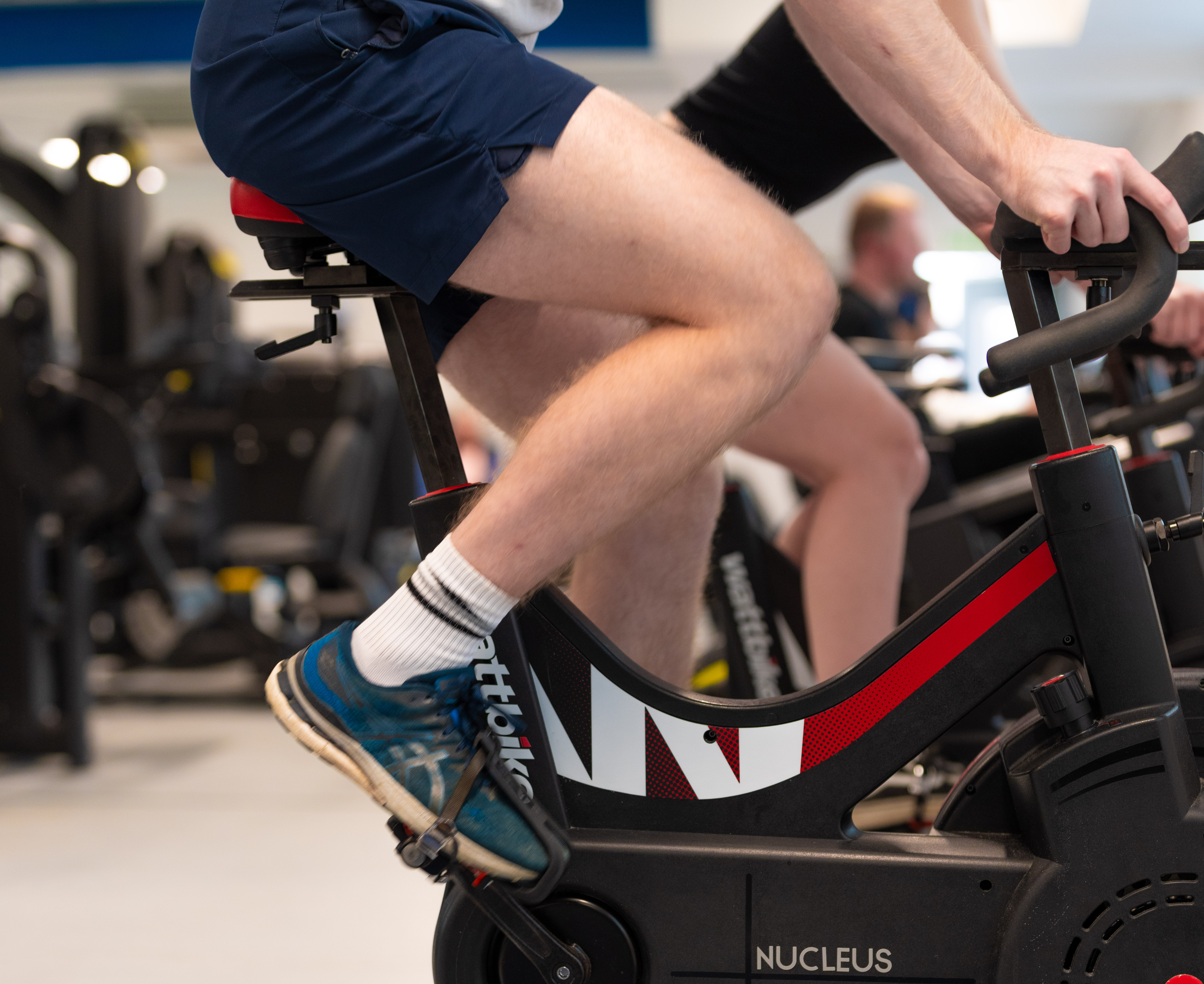 A close up of someone riding a stationary bike in a gym.