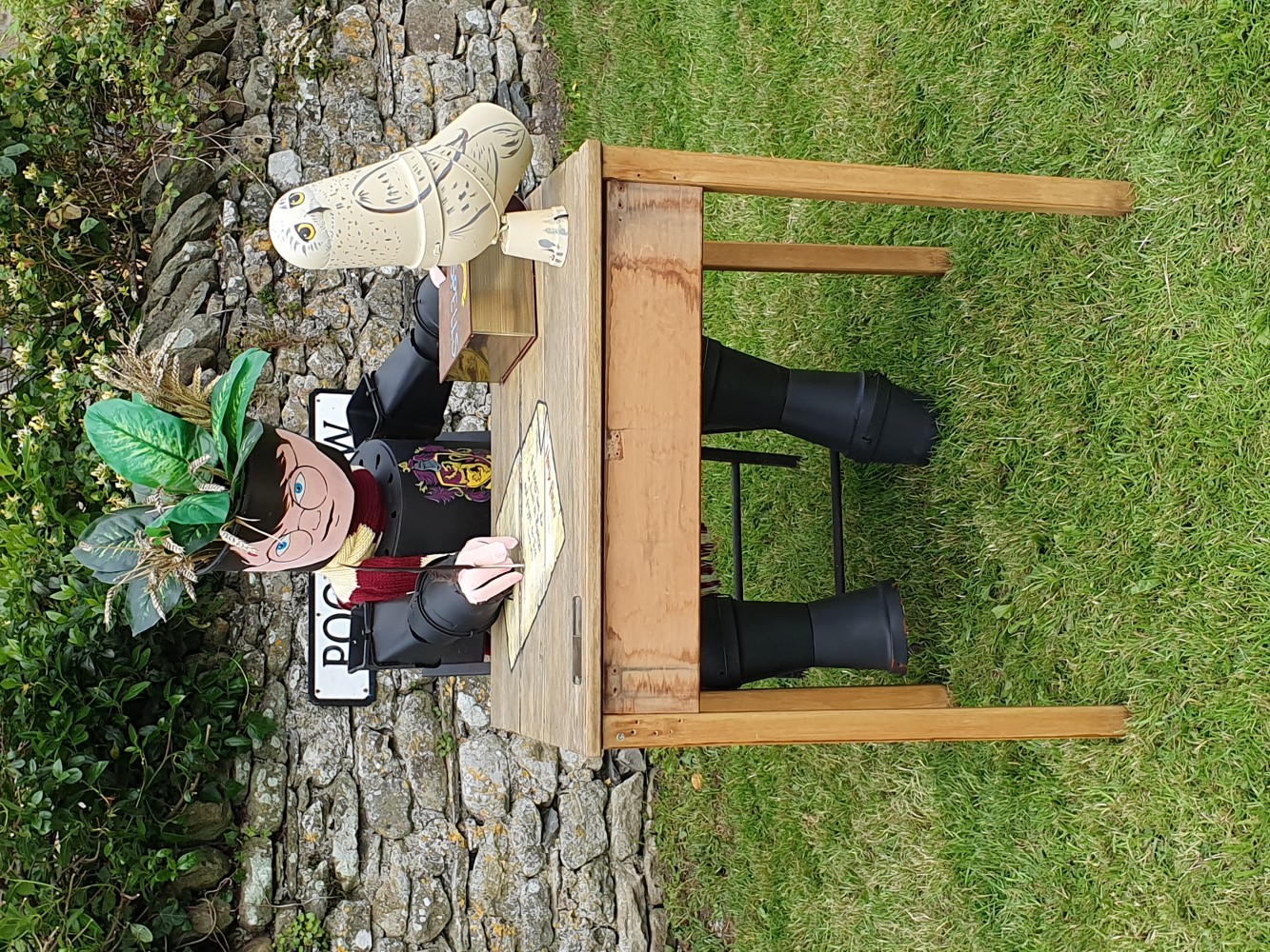 Harry Potter and Hedwig made from flowerpots sitting at a desk