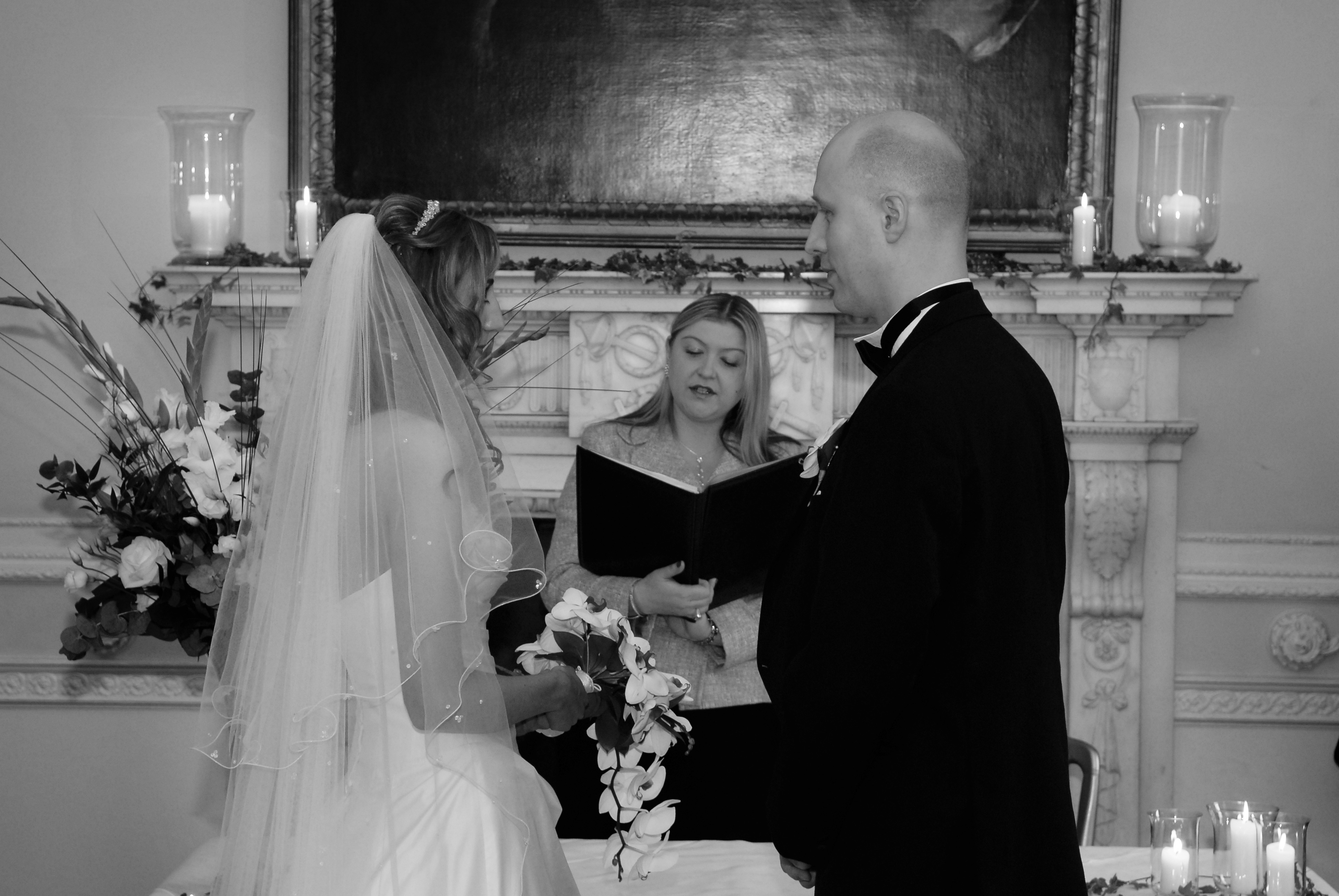 Black and white photo of bride and groom with celebrant
