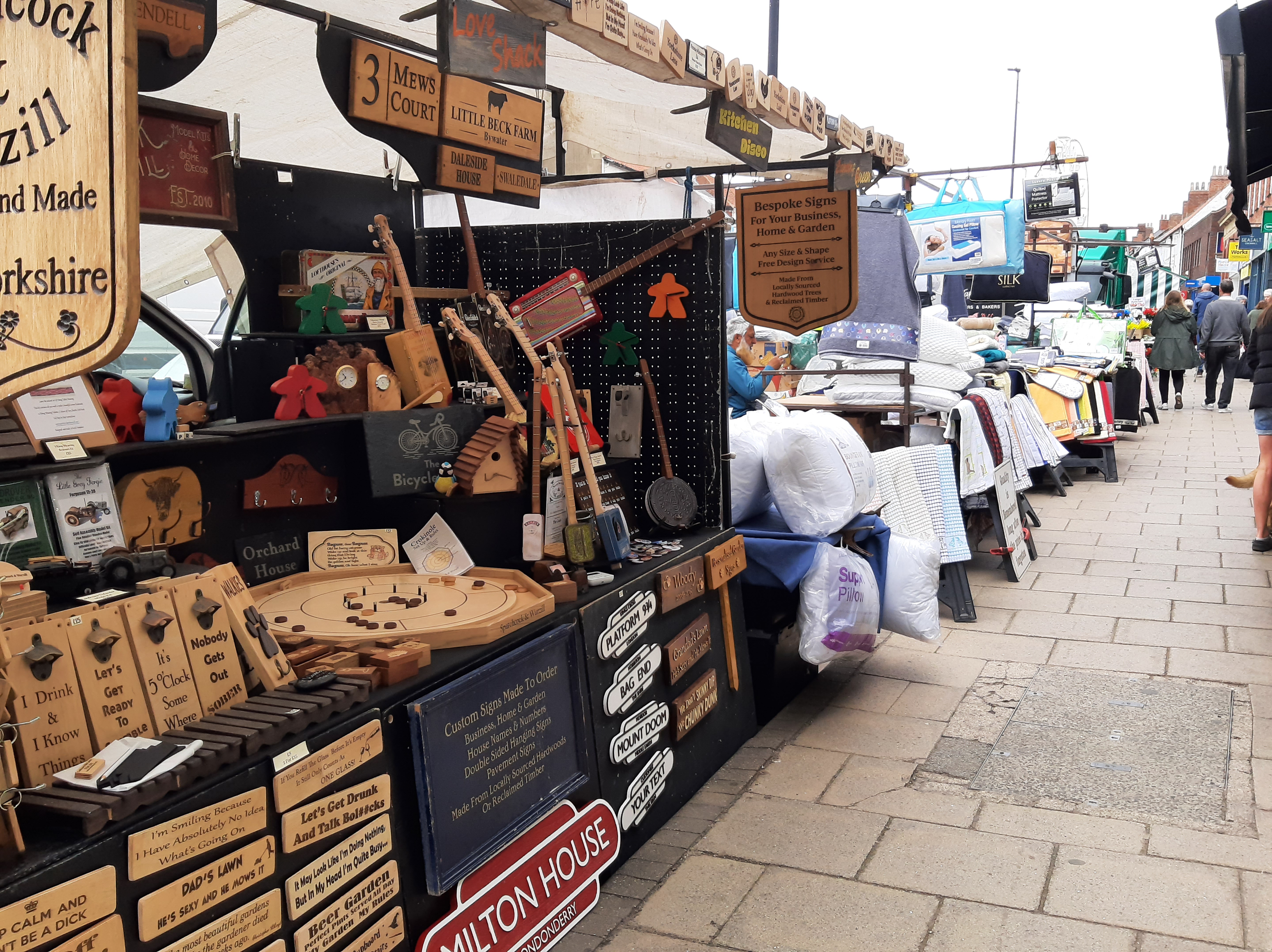 Market stalls alongside the pavement in a high street.