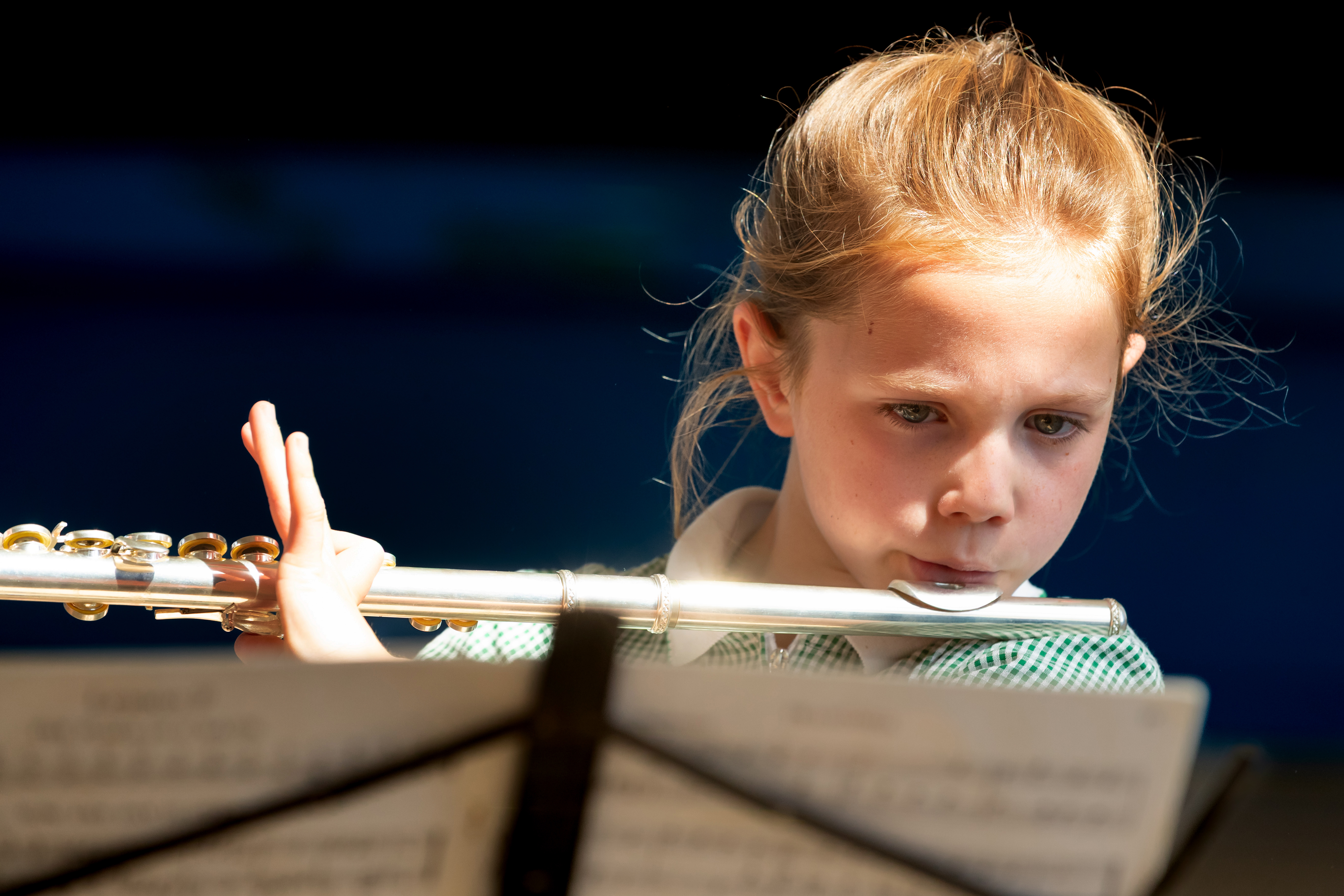 Child standing playing a musical instrument