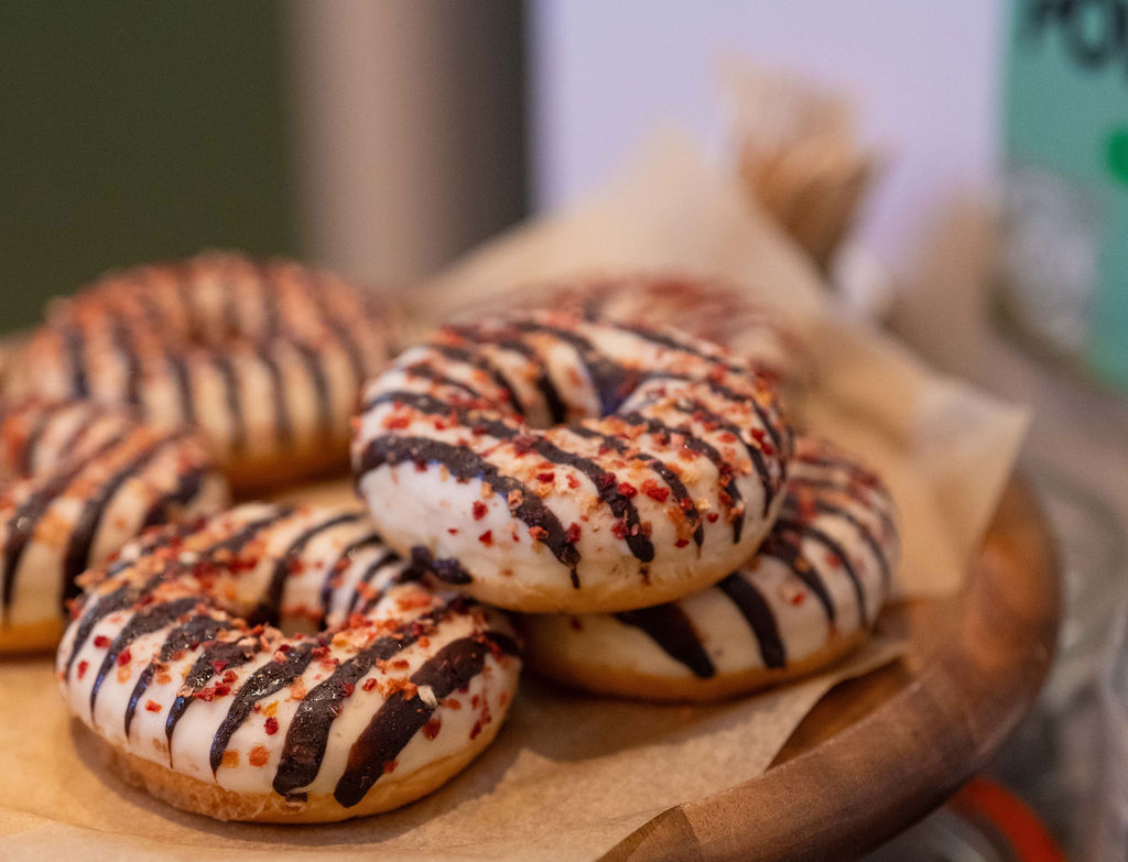 A pile of doughnuts with brown and cream striped icing.