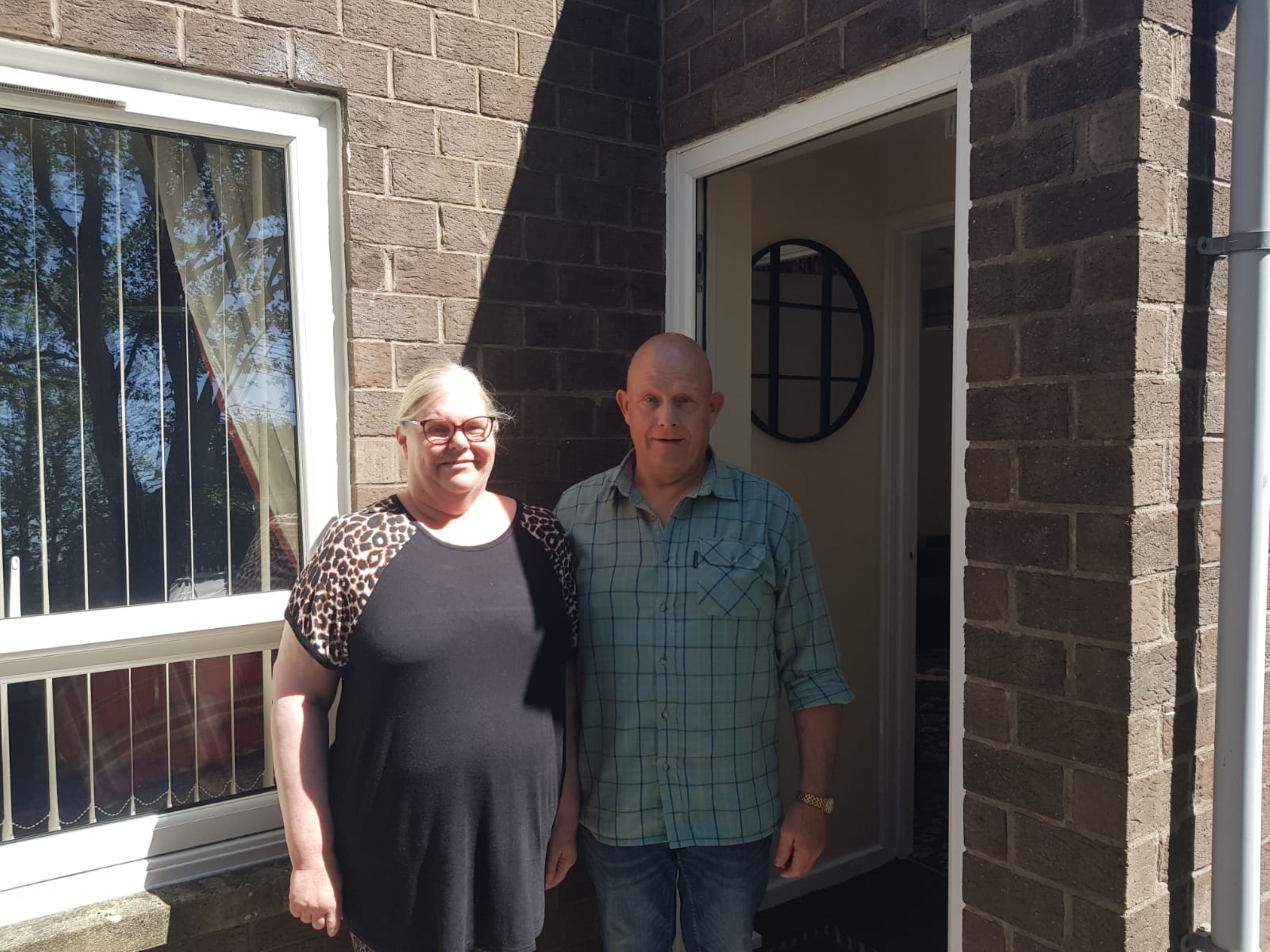 Two people outside a home