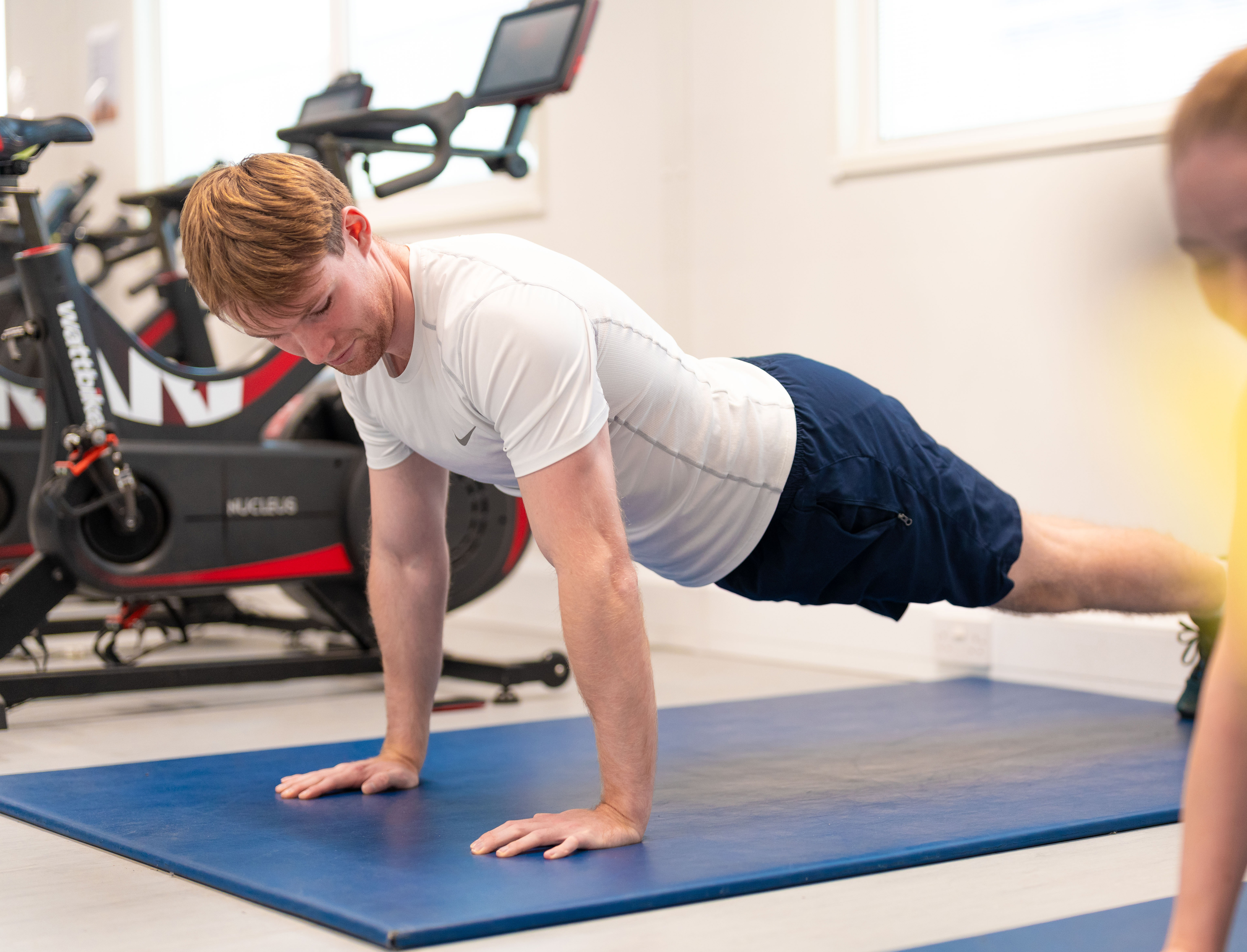 Person exercising on an exercise mat inside in a studio