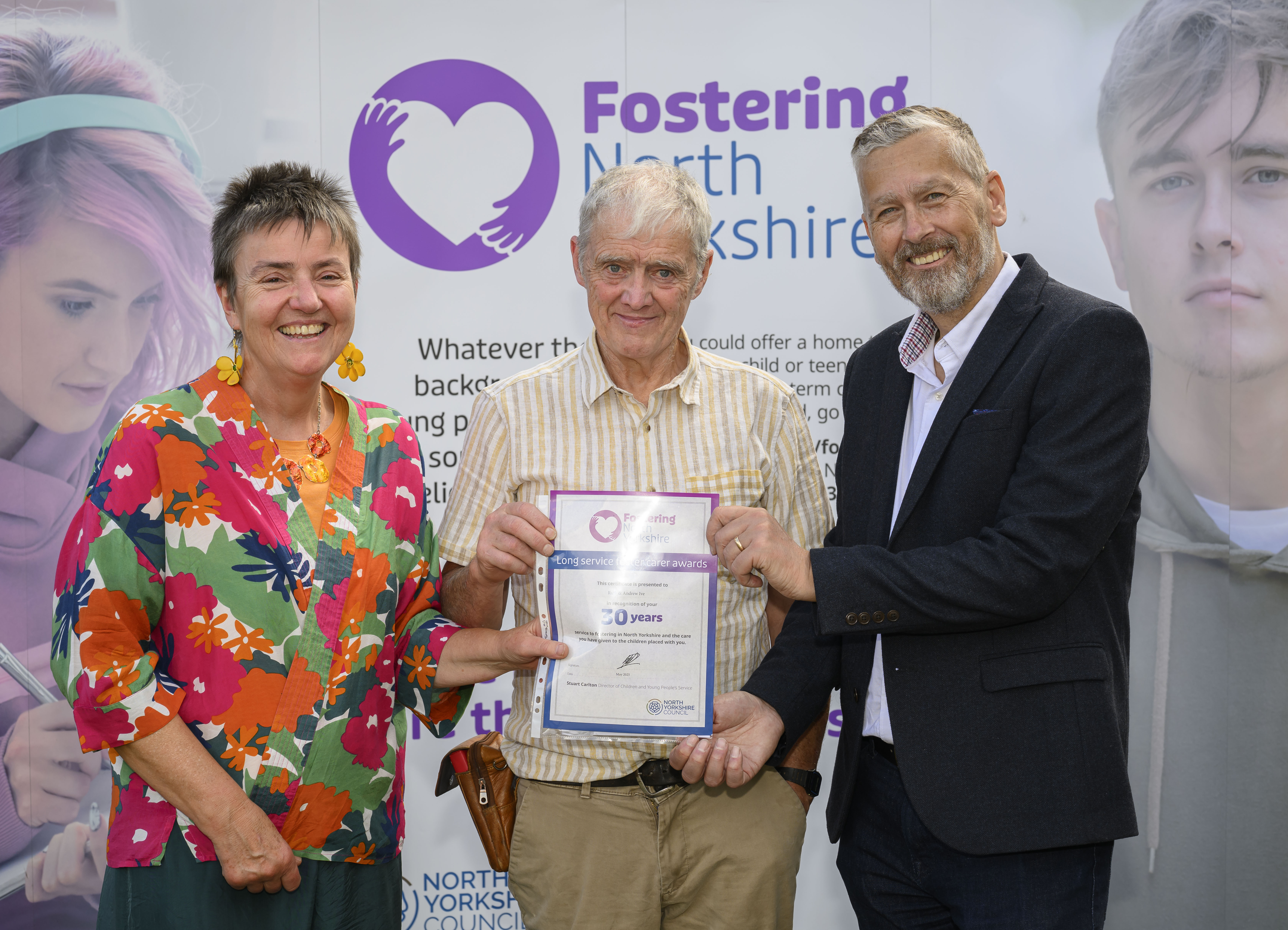 Couple receiving an award for 30 years of fostering