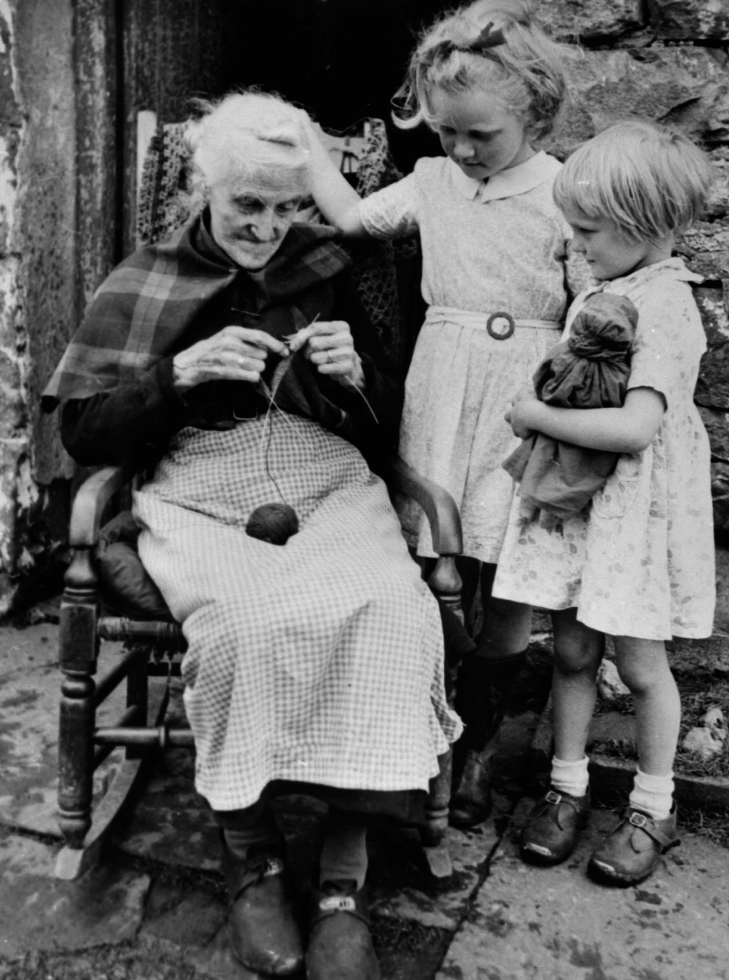 Martha Dinsdale, of Appersett, knitting outside her home. From the Bertram Unné photographic collection.