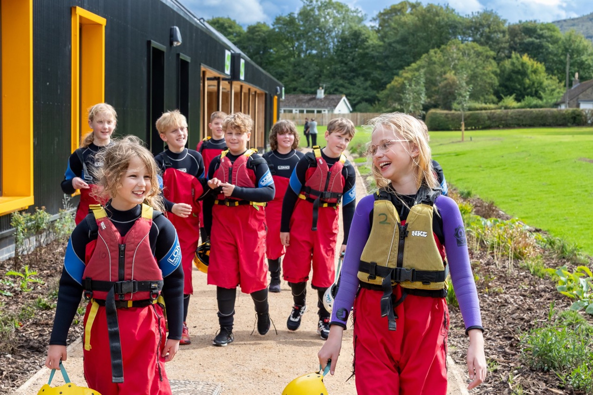 Group of children walking beside the accommodation block at Bewerley Park Outdoor Learning Centre