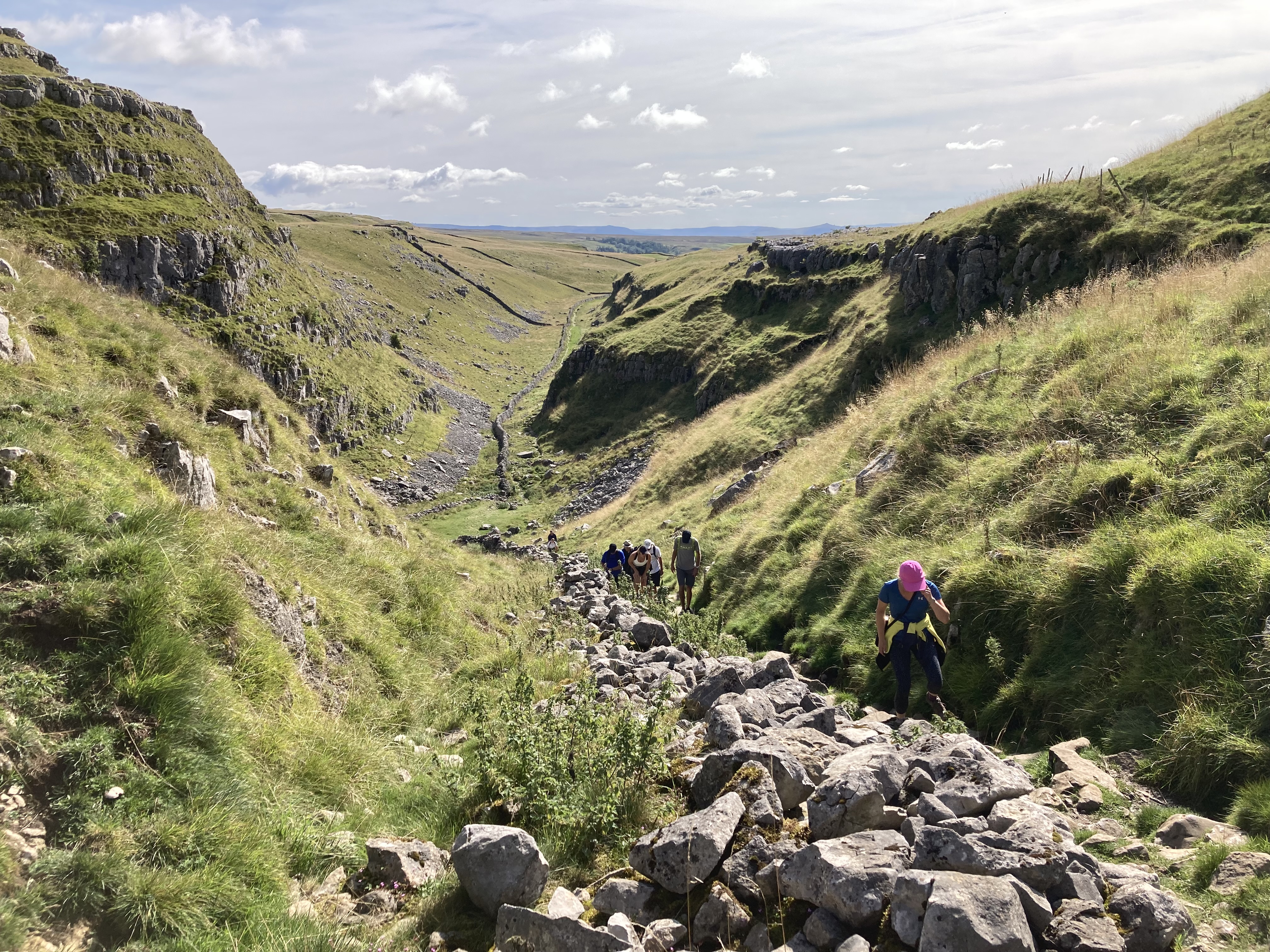 Group of people walking on a rocky path in the Yorkshire Dales