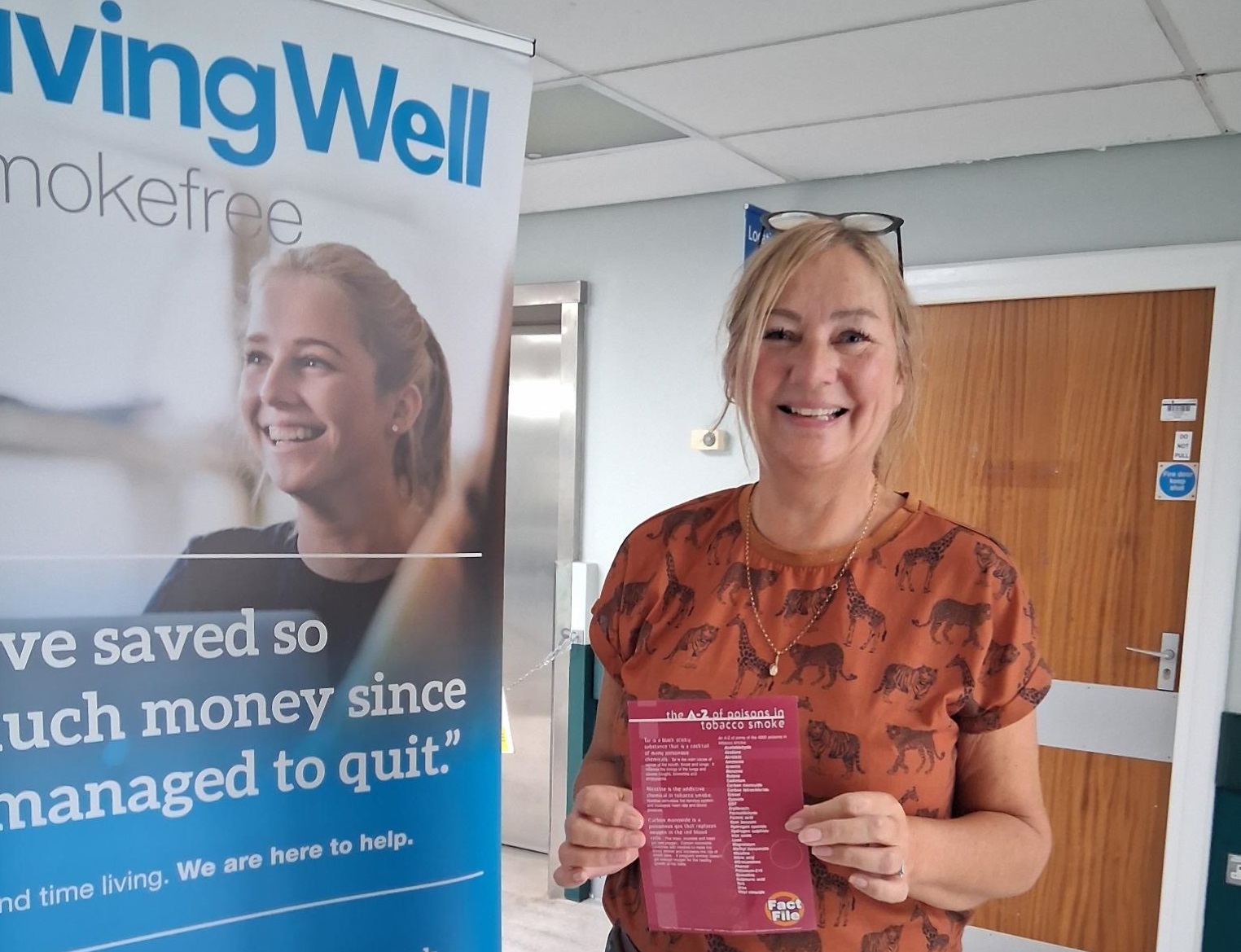 Picture of Deborah Rhodes standing next to Living Well Smoke Free banner