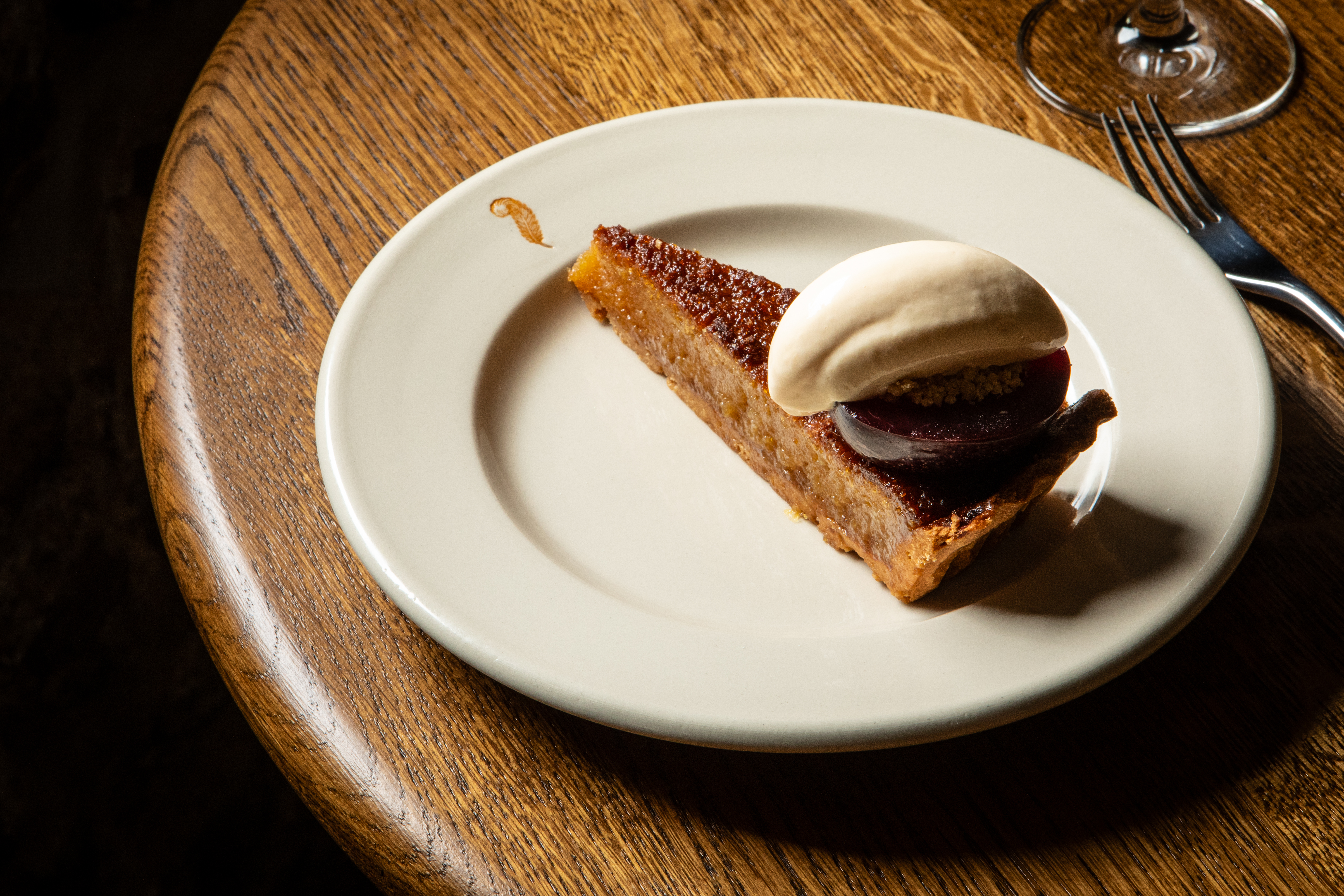 Slice of dessert on a white china plate on a round wooden table