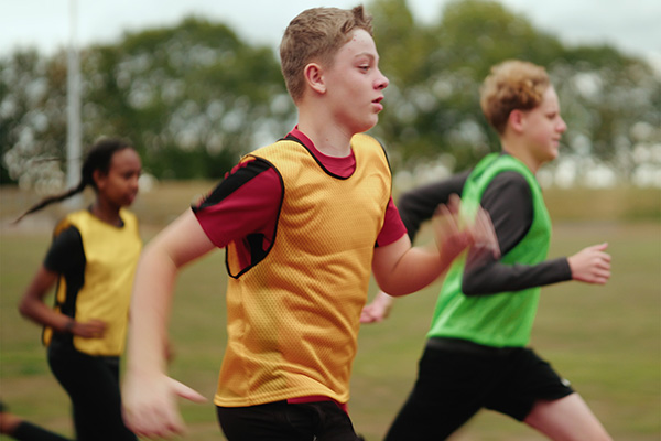 Teenagers running across a sports track