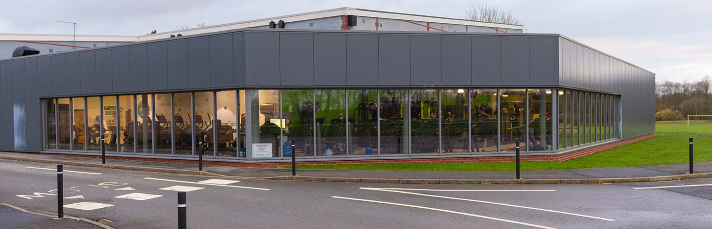 A view of the outside of Northallerton Leisure and Wellbeing Hub, people exercising are just visible within