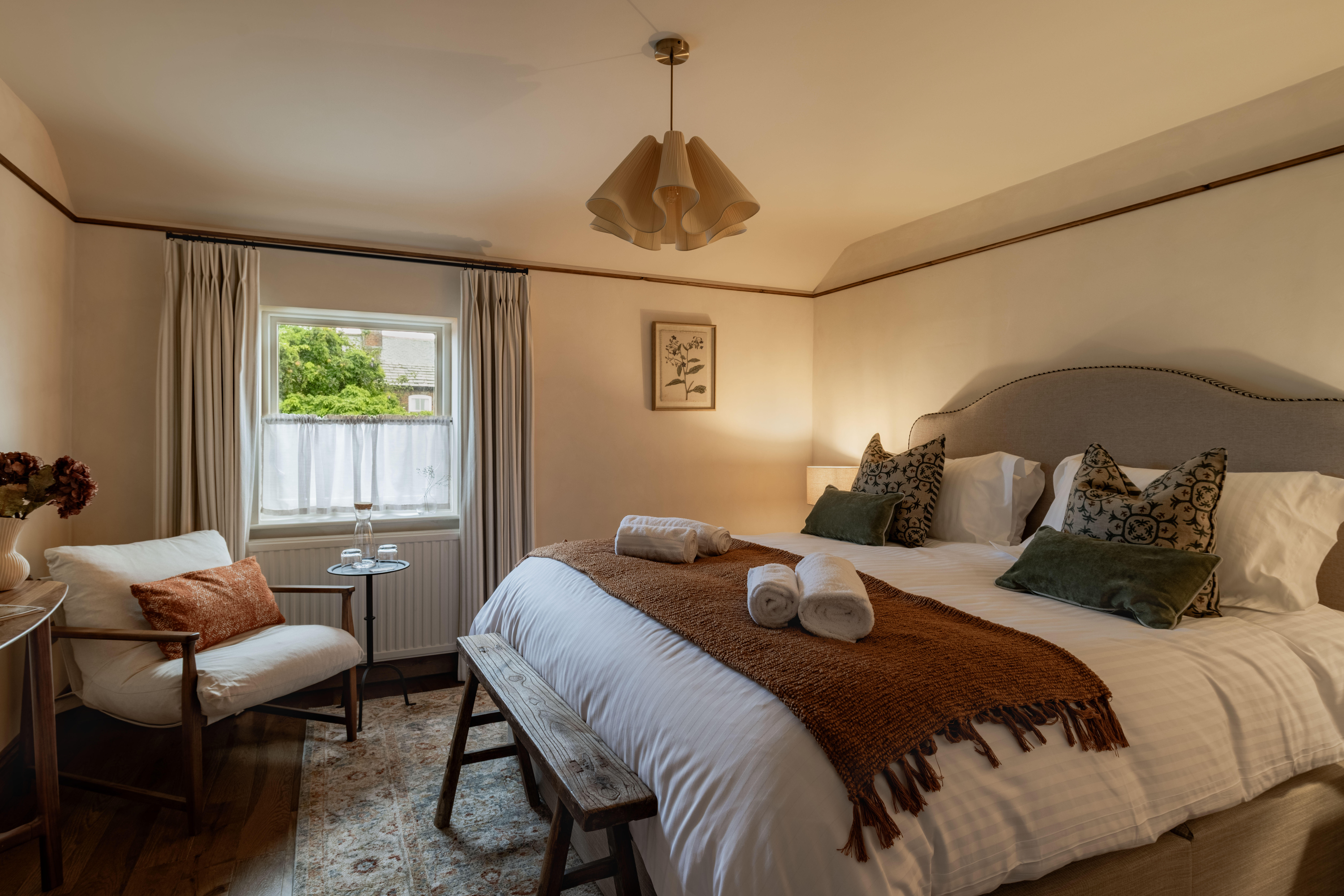 Bedroom with large bed and chair by the window at The General Tarleton