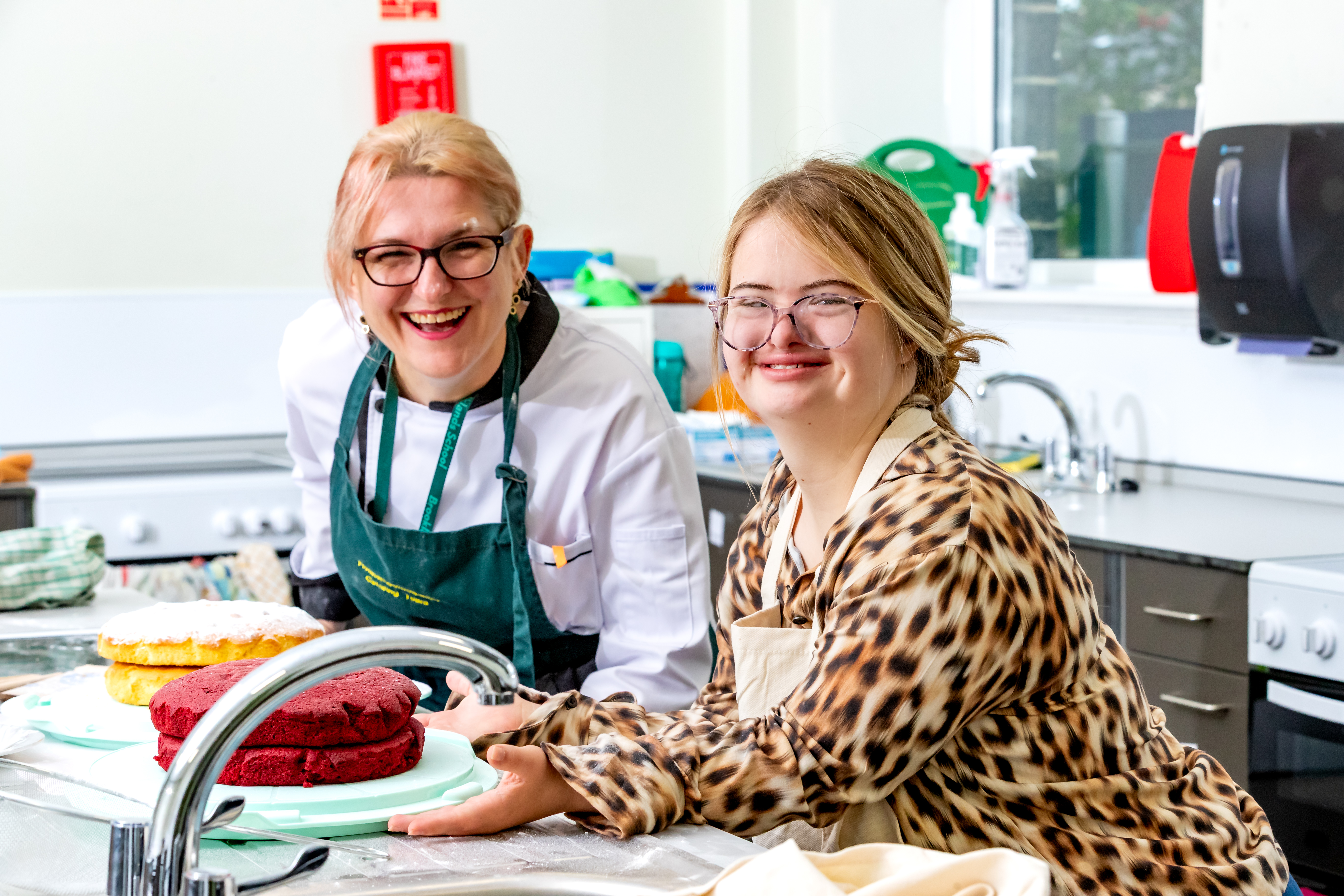 Two people smiling holding their cakes they have baked