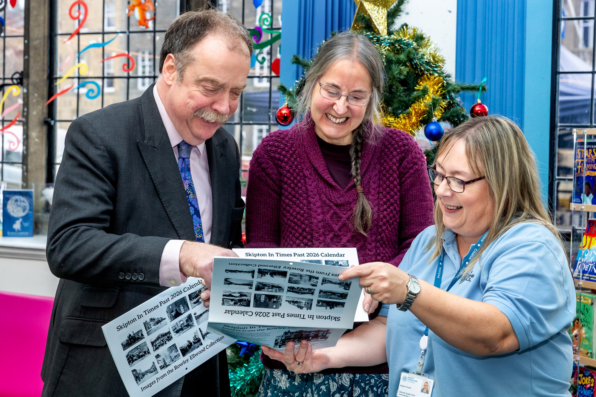 Councillor Myers looking at calendars with two colleagues