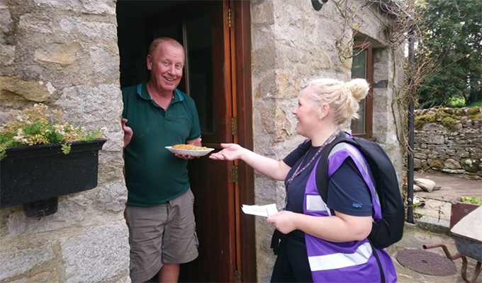 Volunteer delivering food to a house