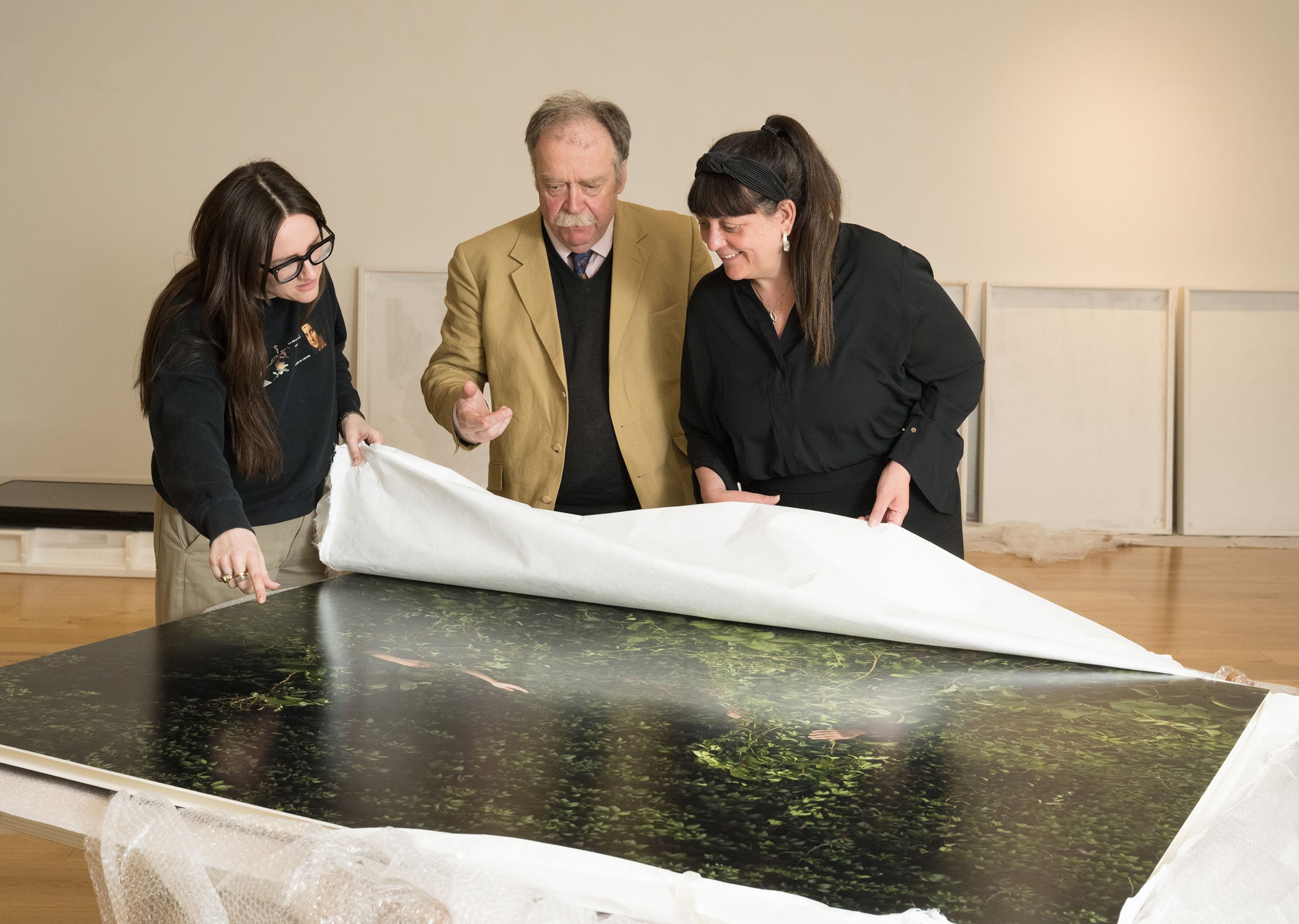 North Yorkshire Council’s exhibitions curator, Megan Hickes with North Yorkshire Council’s executive member for arts and culture, Cllr Simon Myers, and Aesthetica director, Cherie Federico, observe May Parlar’s work 'Collective Solitude' at Skipton Town Hall. The Aesthetica Art Prize exhibition will be staged at four of North Yorkshire Council’s venues from this month.