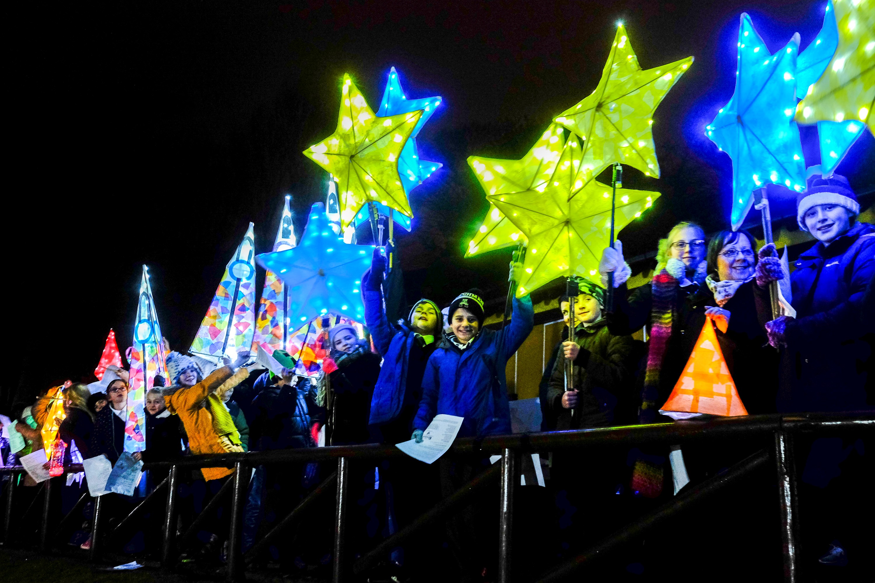 Group of children holding bright lanterns at night