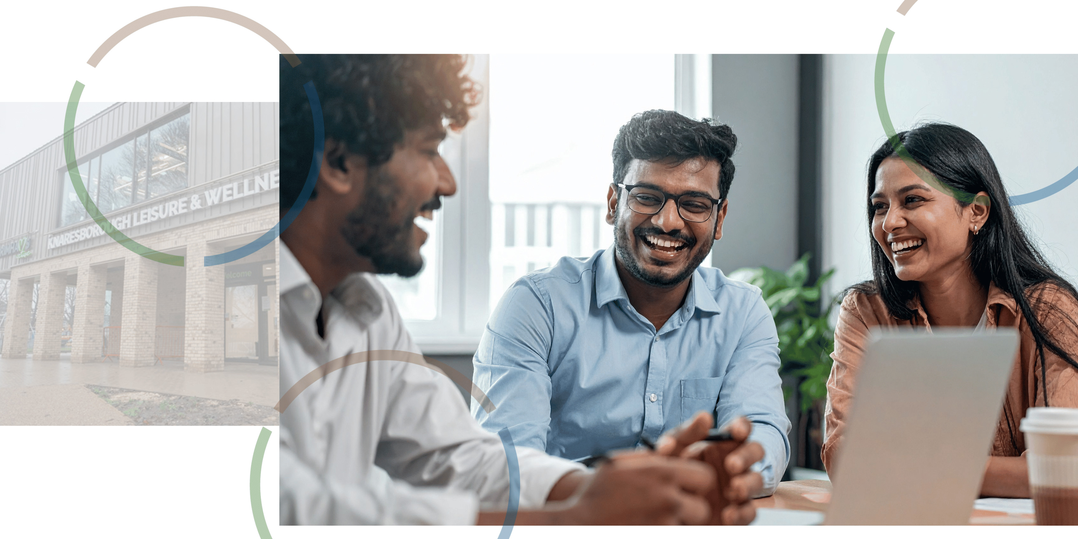 People sitting around and smiling at desk.