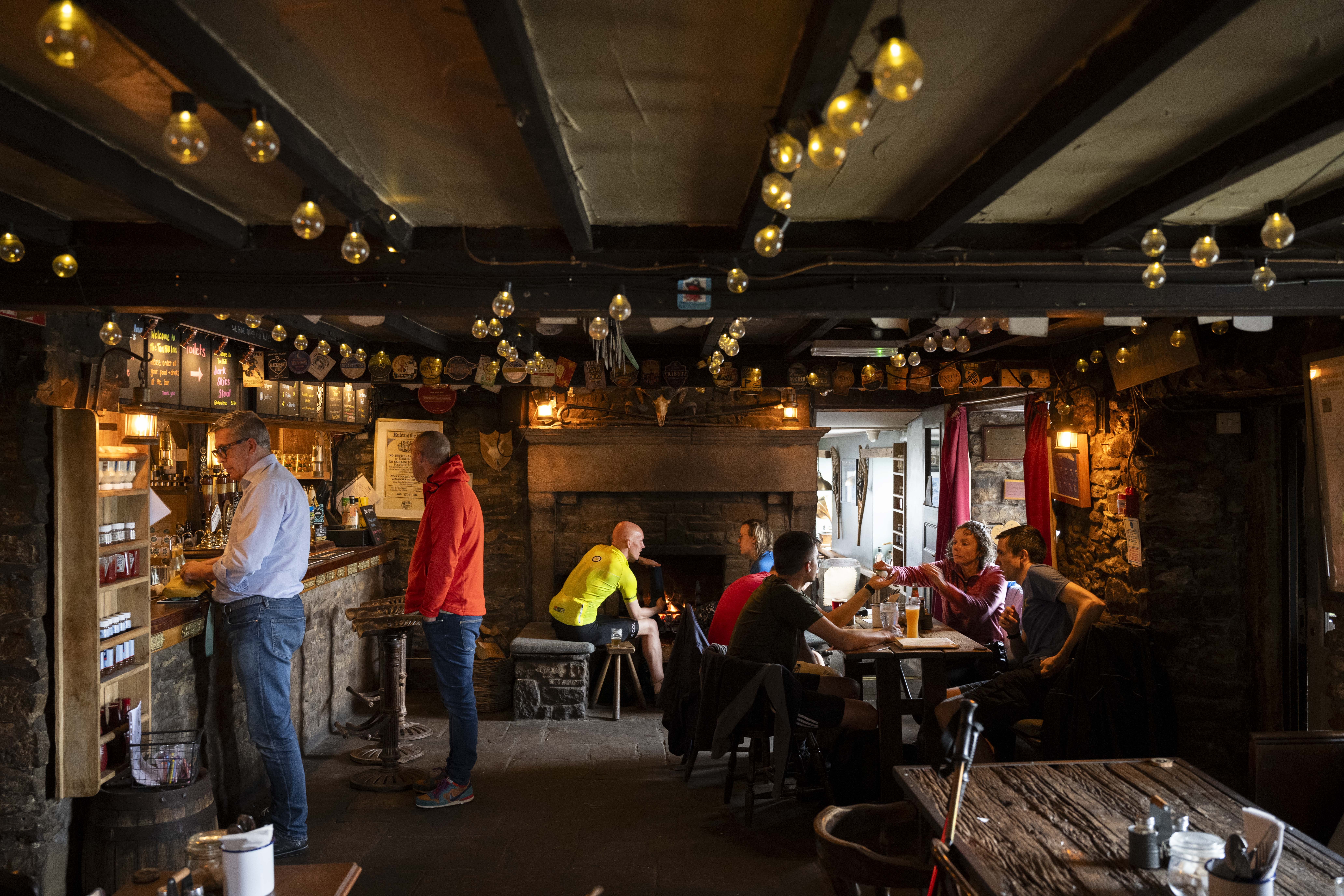 Group of adults standing and sitting in the bar area of an Inn
