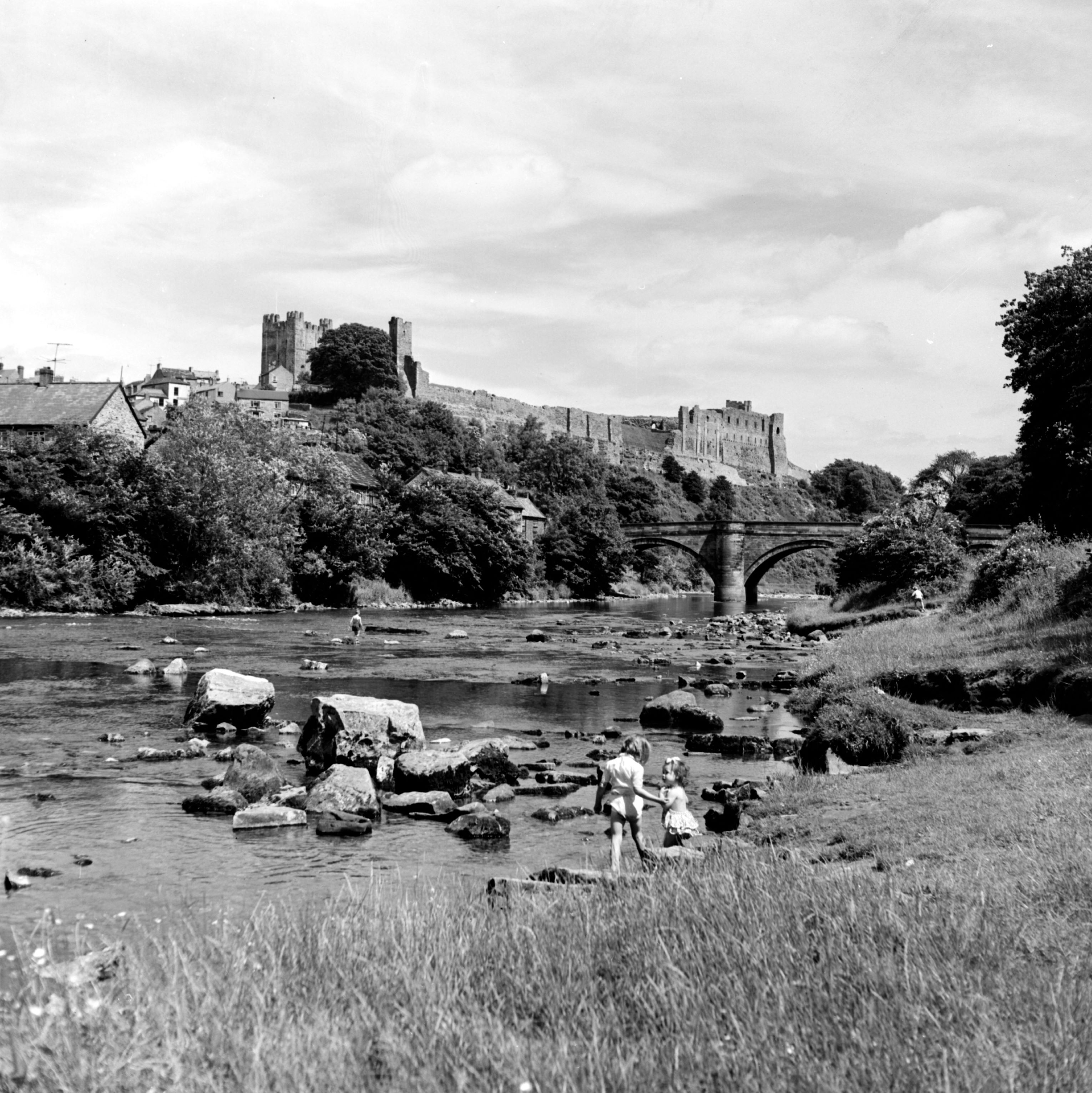Children paddling in the River Swale below Richmond Castle. Taken by local photographer Bertram Unné , active between 1940 and 1979.