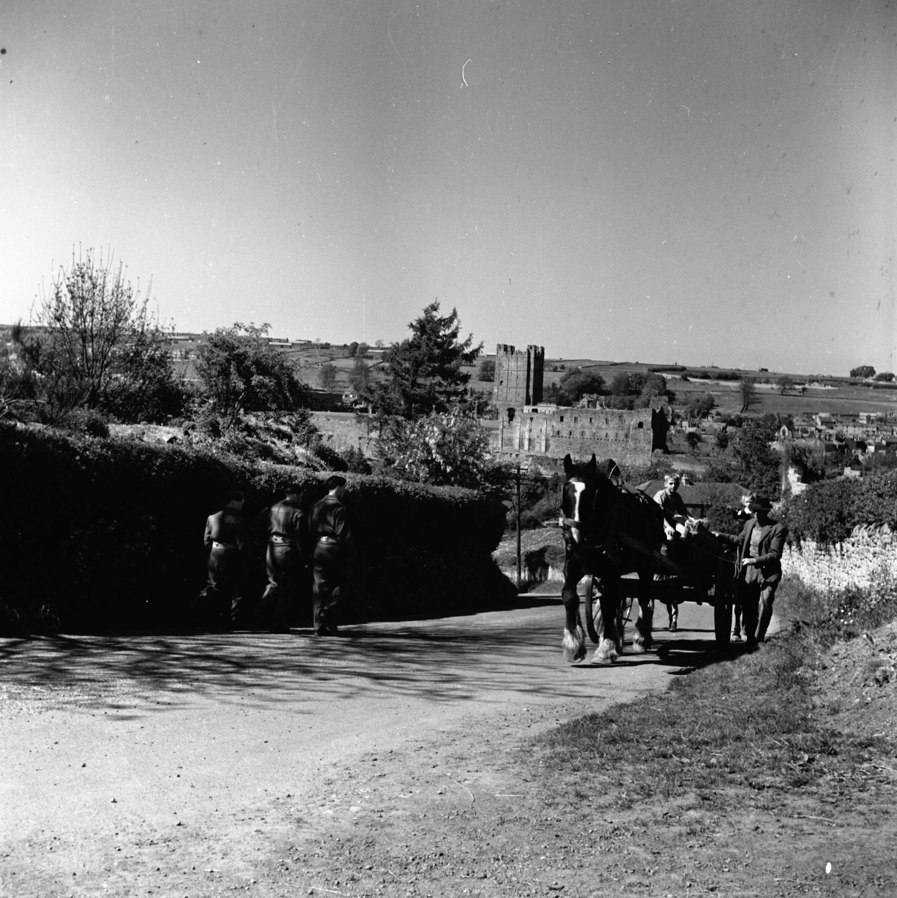 Travelling over the bridge by horse and cart, with Richmond Castle in the distance. Taken by local photographer Bertram Unné, active between 1940 and 1979.