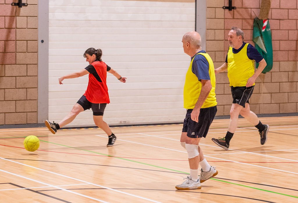 A group of men and women playing five-a-side football in the sports hall at Northallerton Leisure and Wellbeing Hub