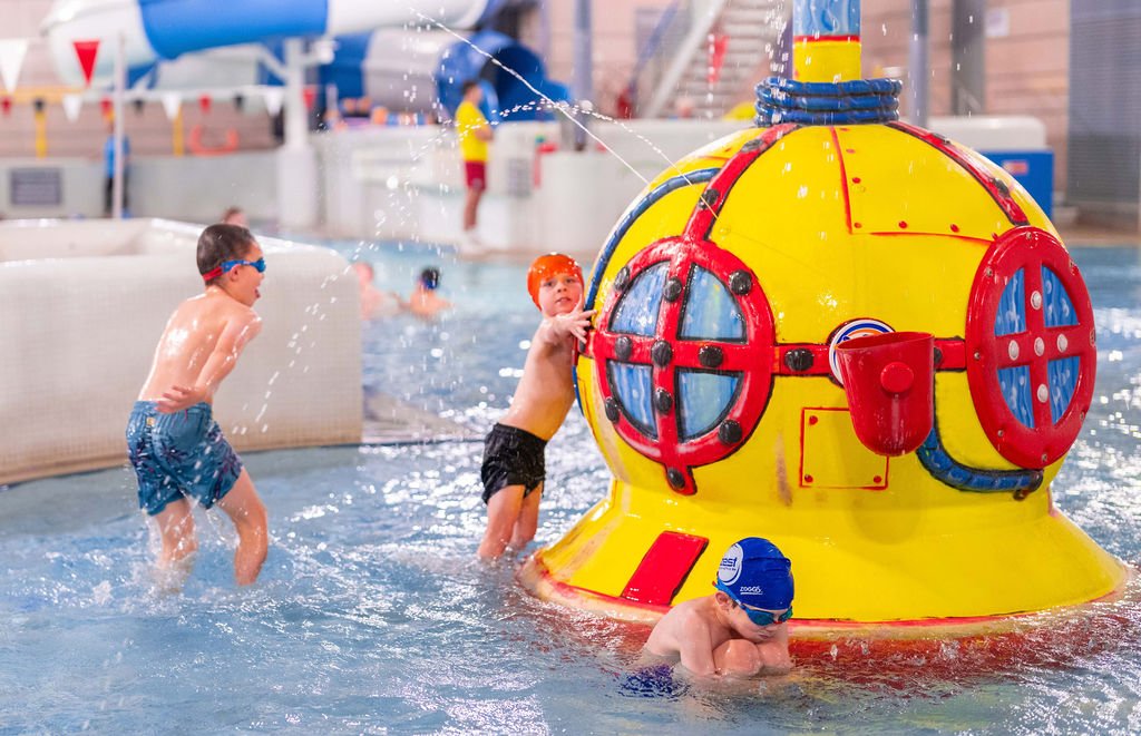 A group of children play in the water alongside the submarine fountain in Northallerton Leisure and Wellbeing Hub's swimming pool