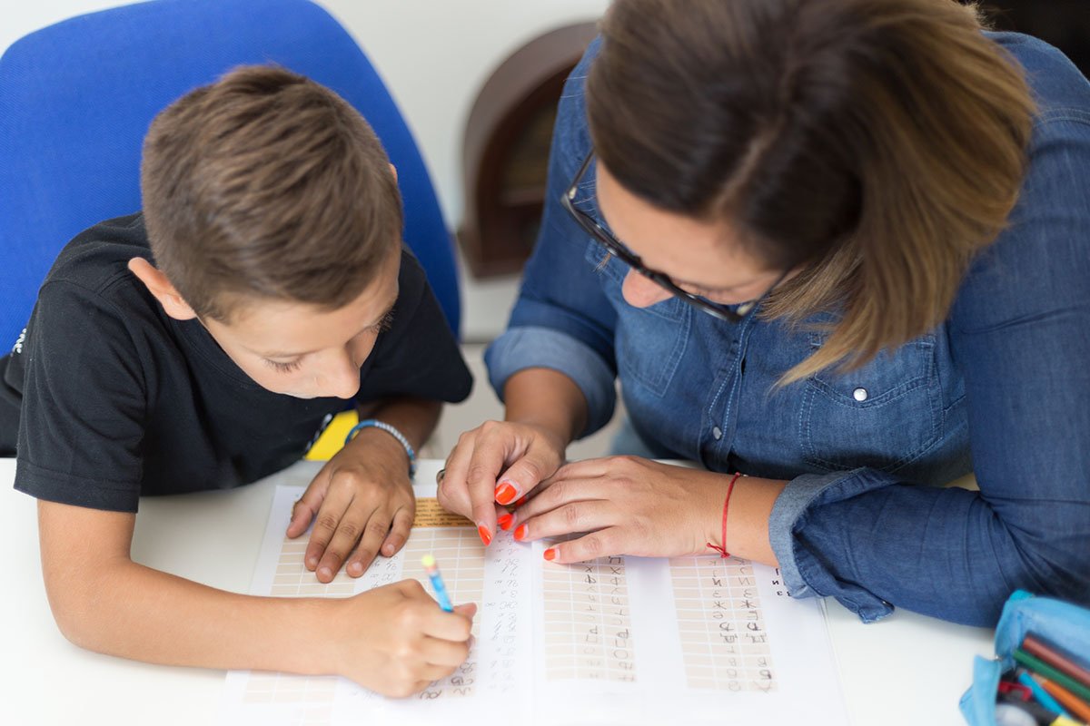 Woman and young boy doing homework together.
