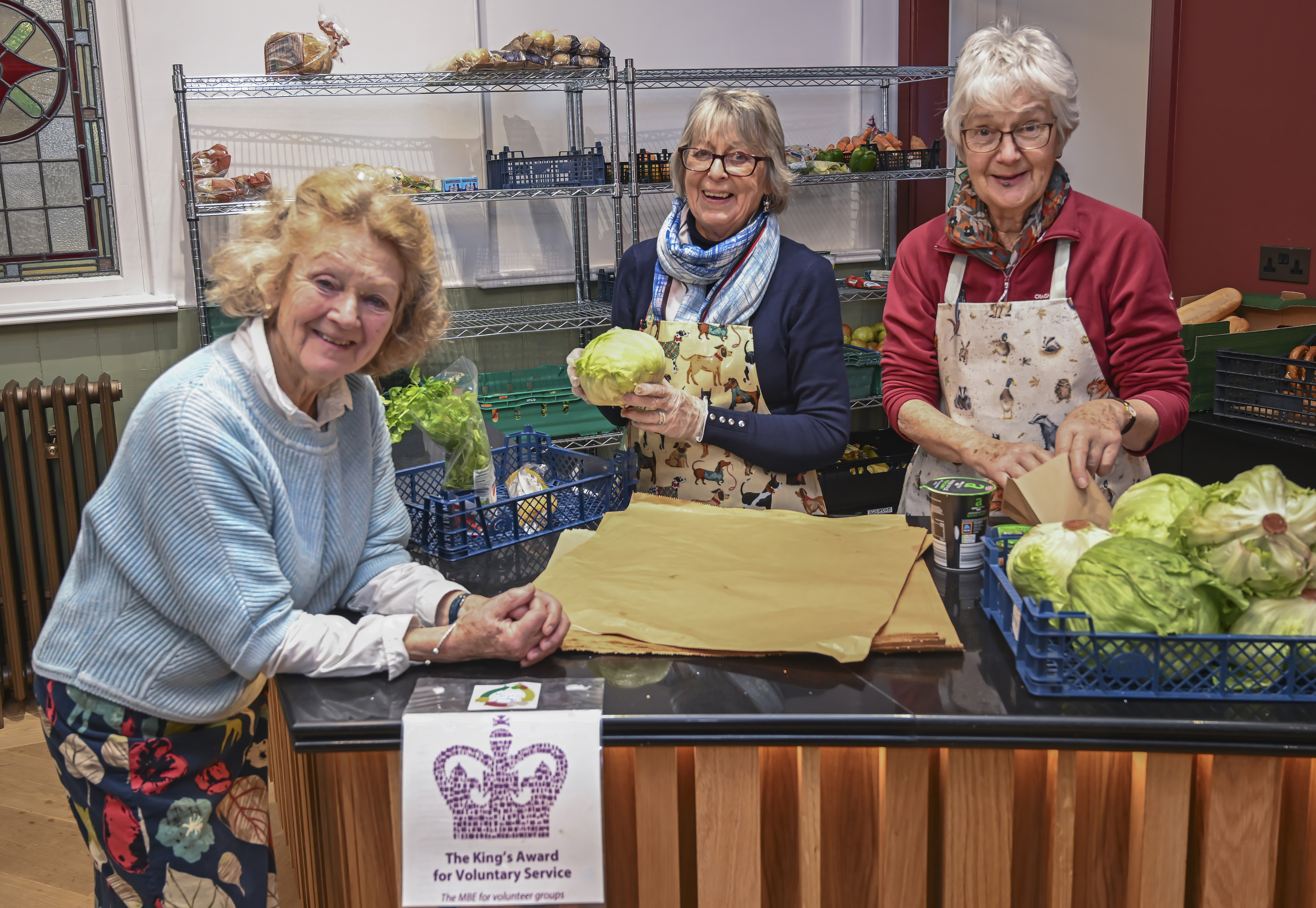 Three ladies behind a table with food