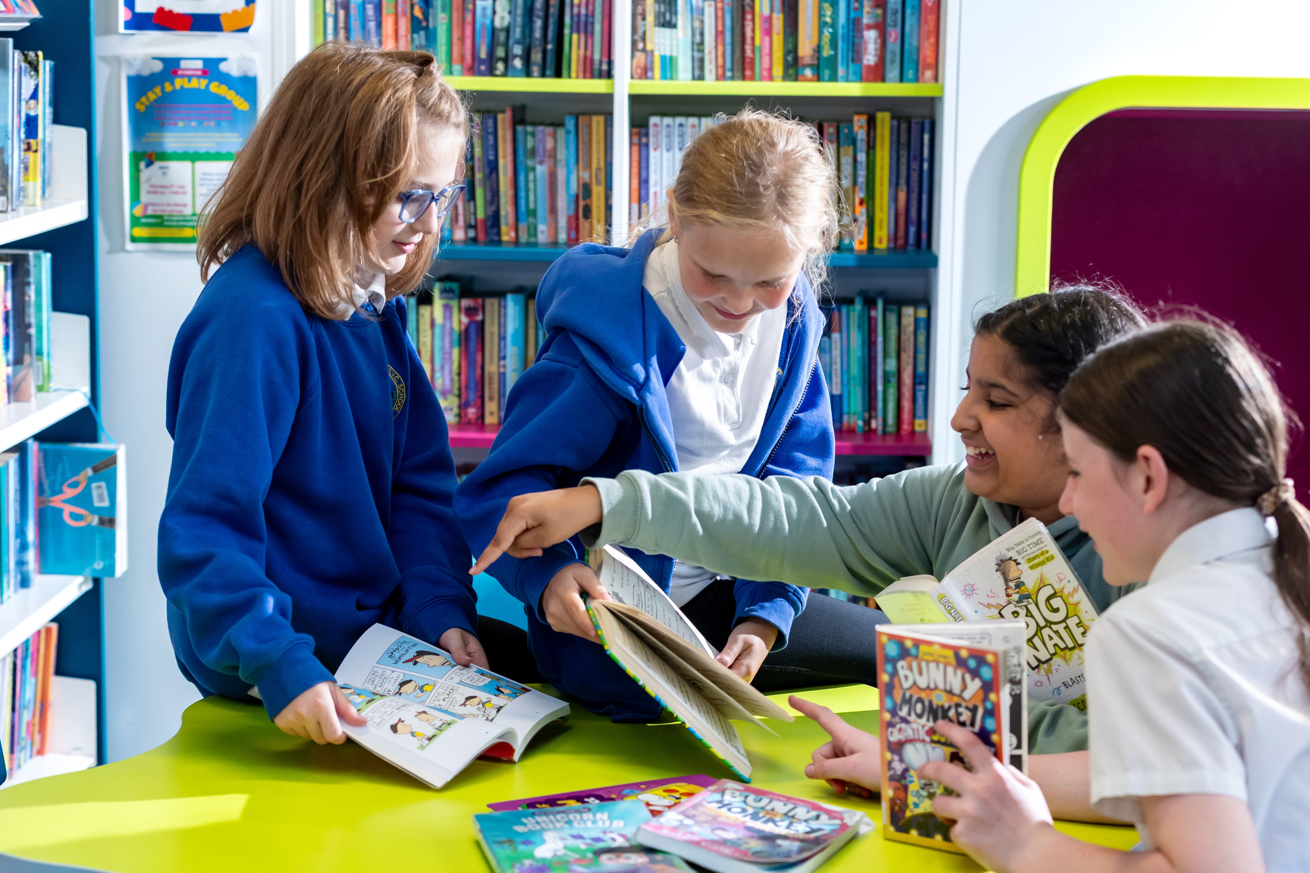 Small group of children sitting together holding books