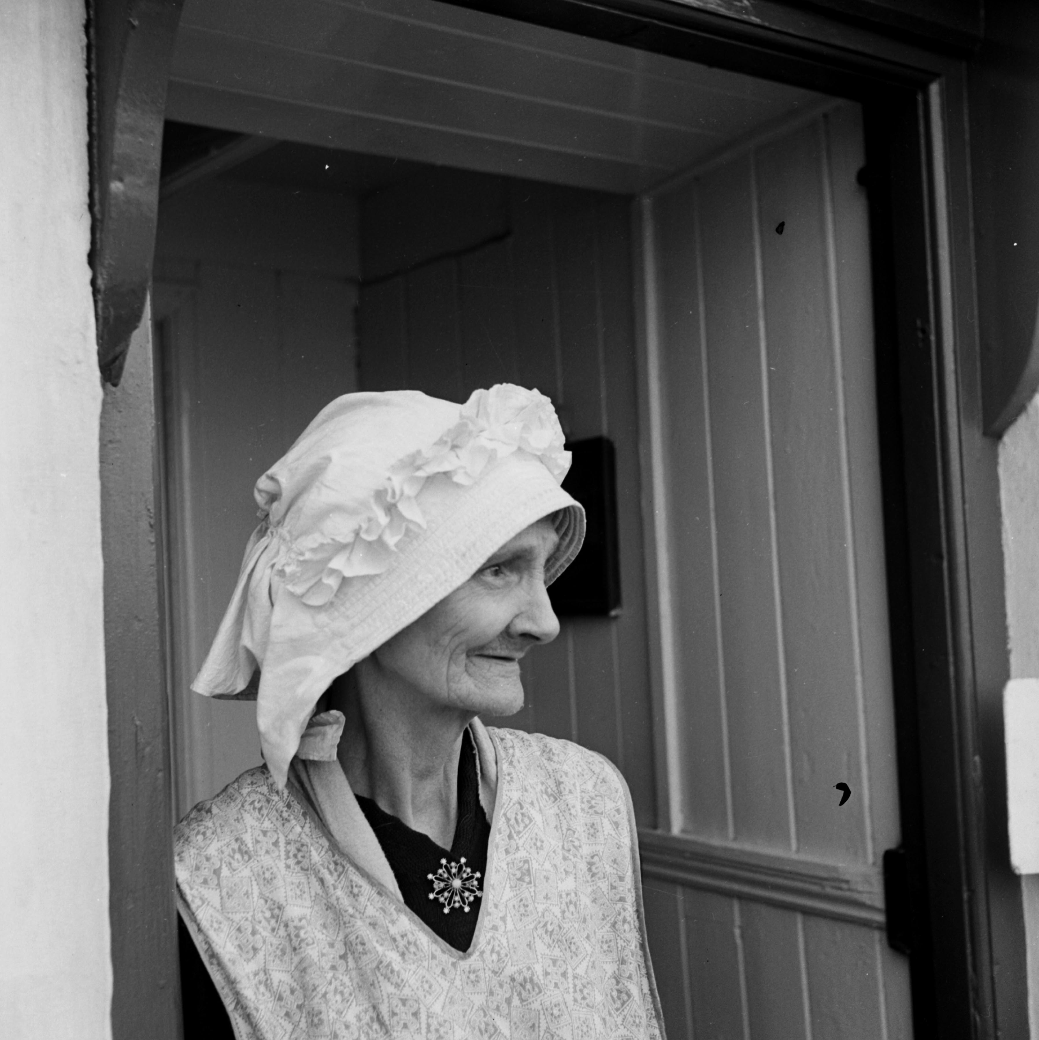 Lily Thompson is pictured wearing her Staithes bonnet. The bonnet is padded to protect the head and the long frill at the back is intended to prevent the drips of water running down the neck. Taken by local photographer Bertram Unné, active between 1940 and 1979.