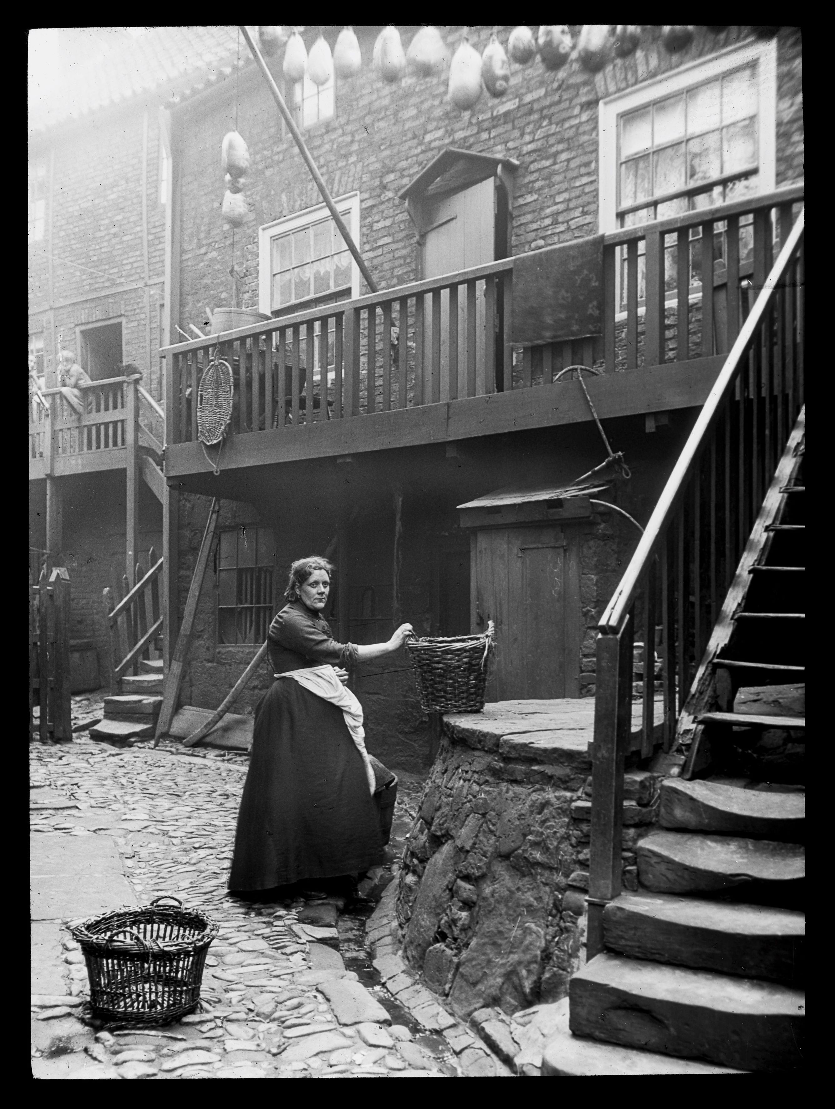 A woman is pictured holding a basket in Wilson’s Yard in Whitby. The photo is undated and was taken by Graystone Bird (1862-1943). It is taken from the ‘Tour of Yorkshire’ photographic collection.