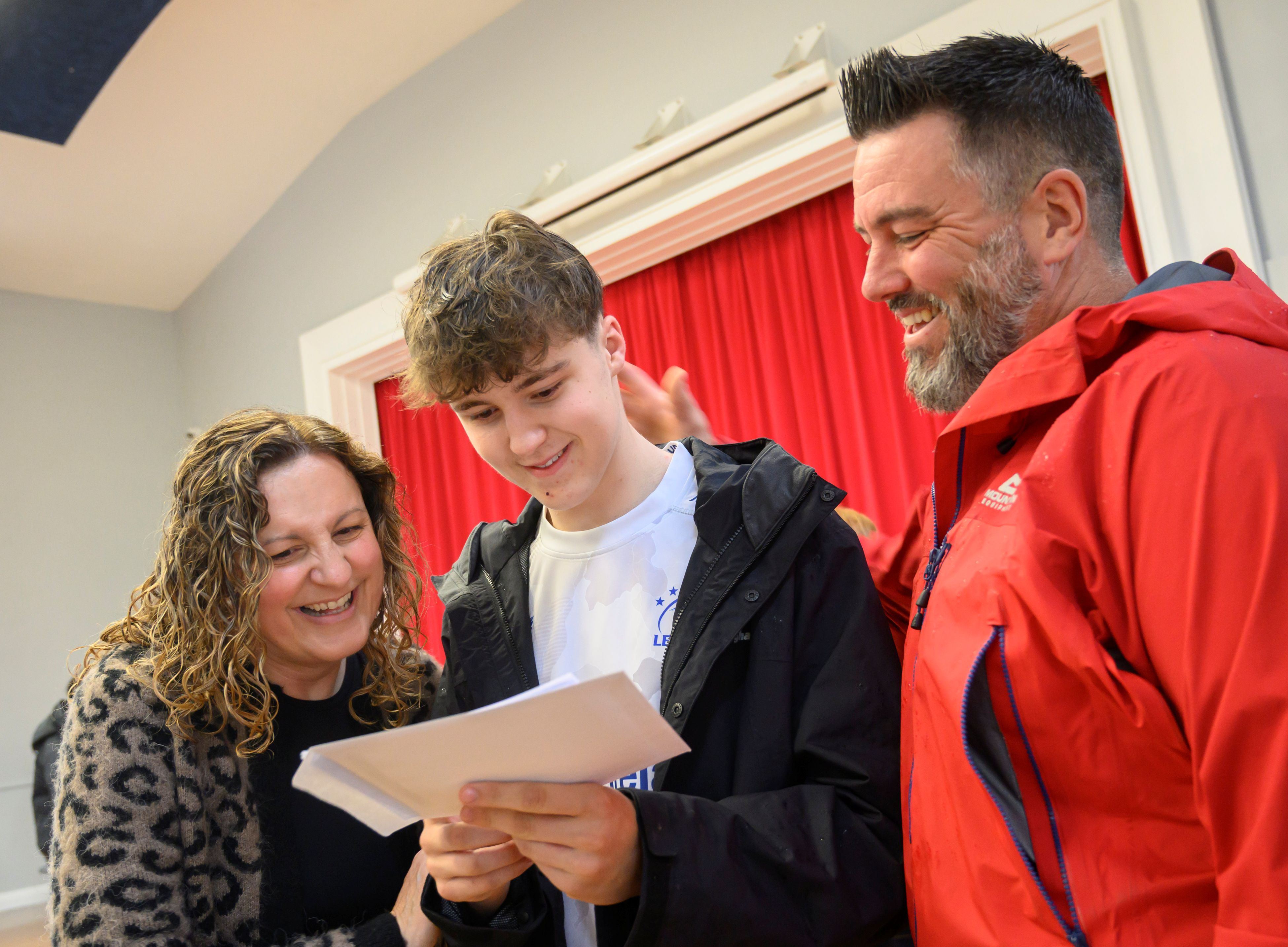 A student with parents looking at GCSE results.