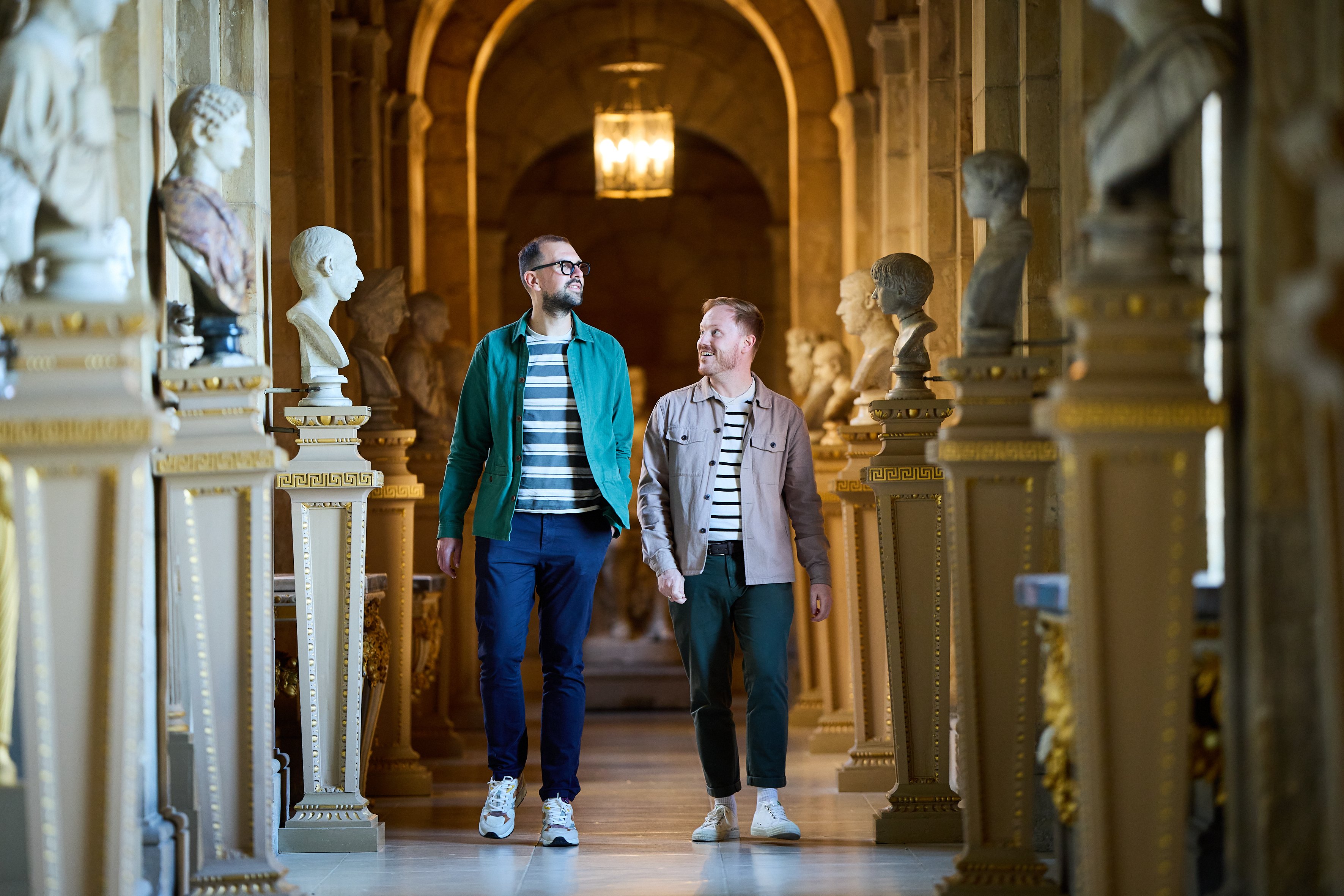 Two adults walking through Castle Howard looking at the sculptures