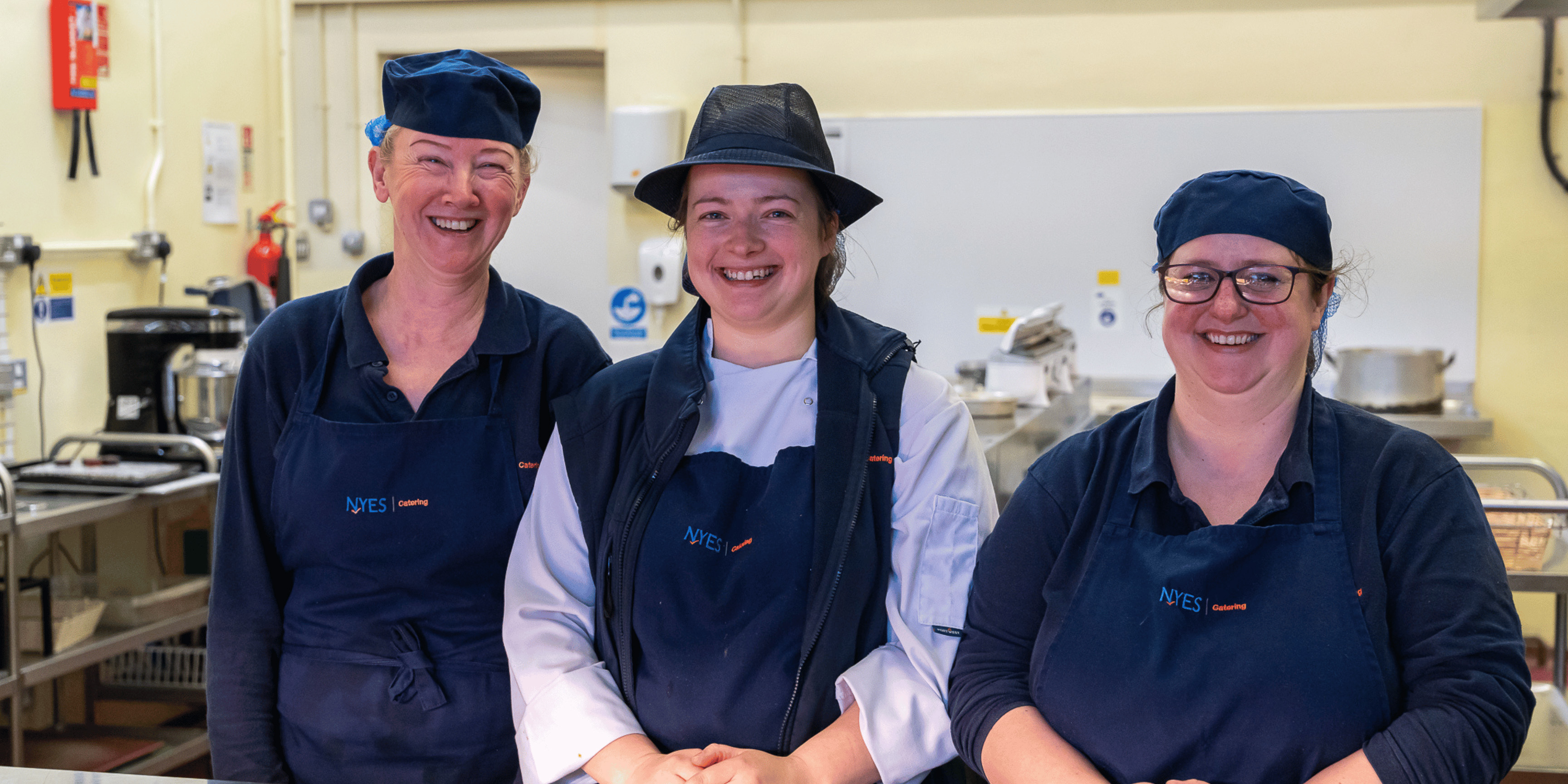 Cooks smiling in school kitchen