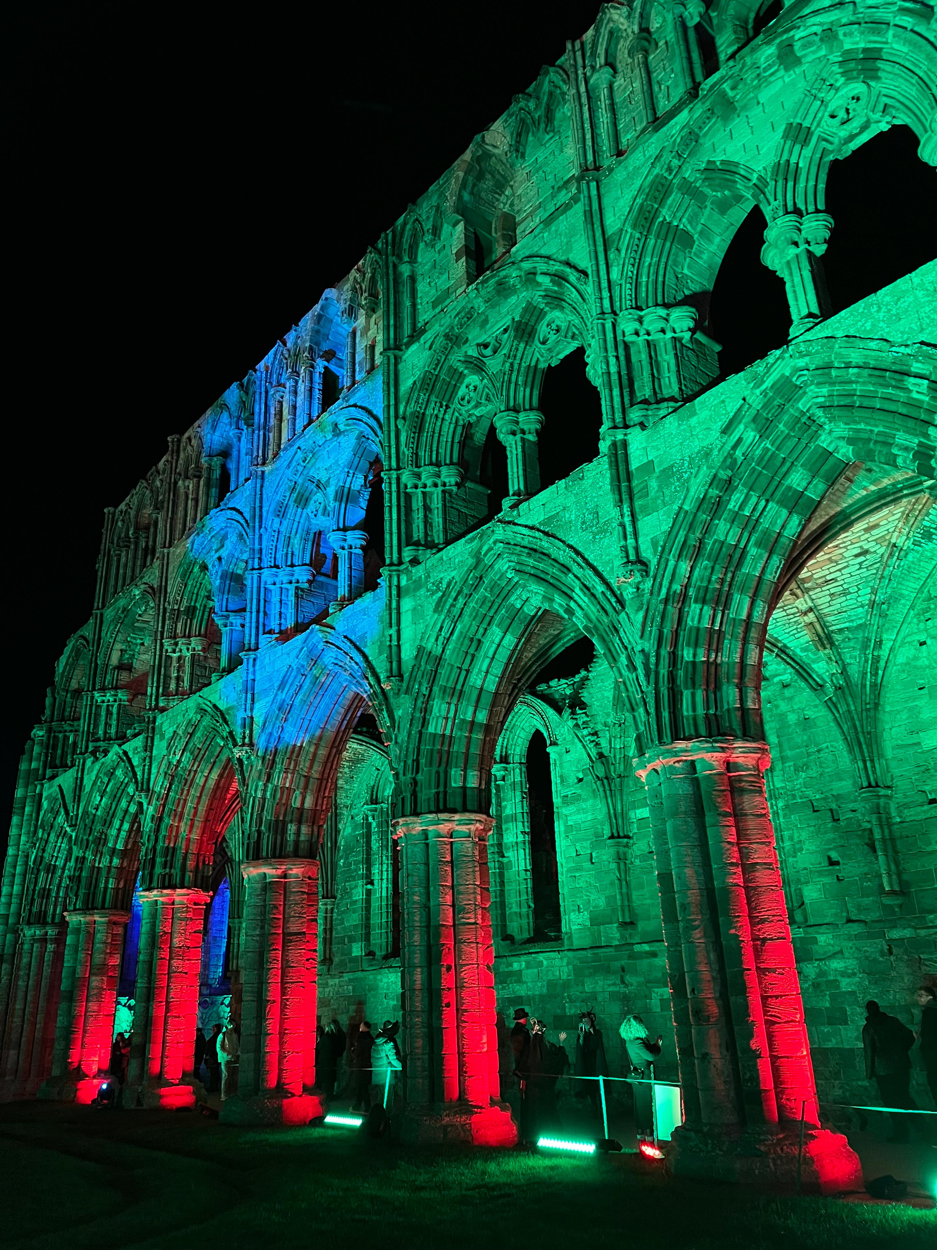 Fountains Abbey illuminated in red, green and blue at night