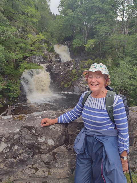 A photo of Roselene standing in front of a waterfall