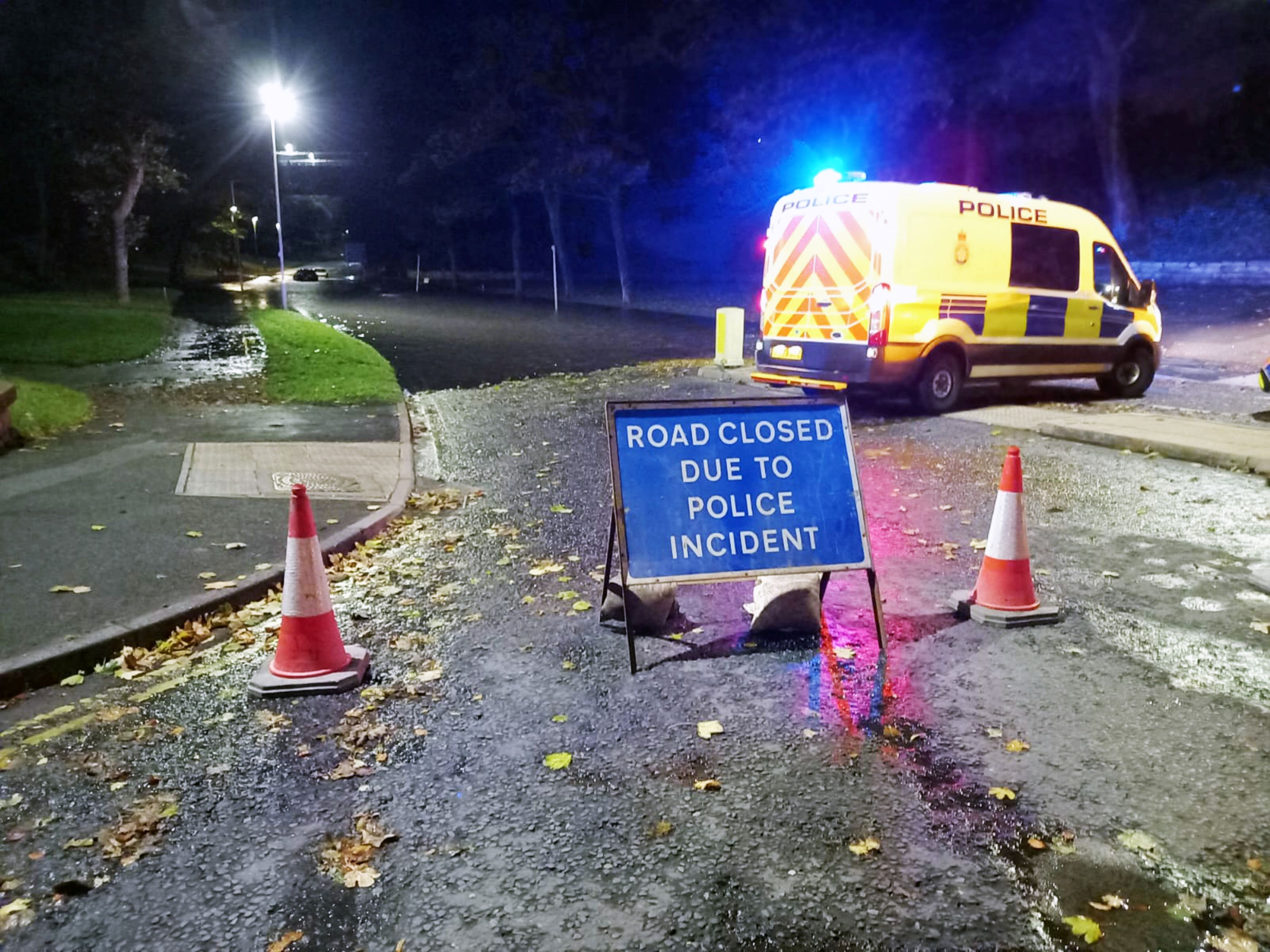 A road closure sign and police van