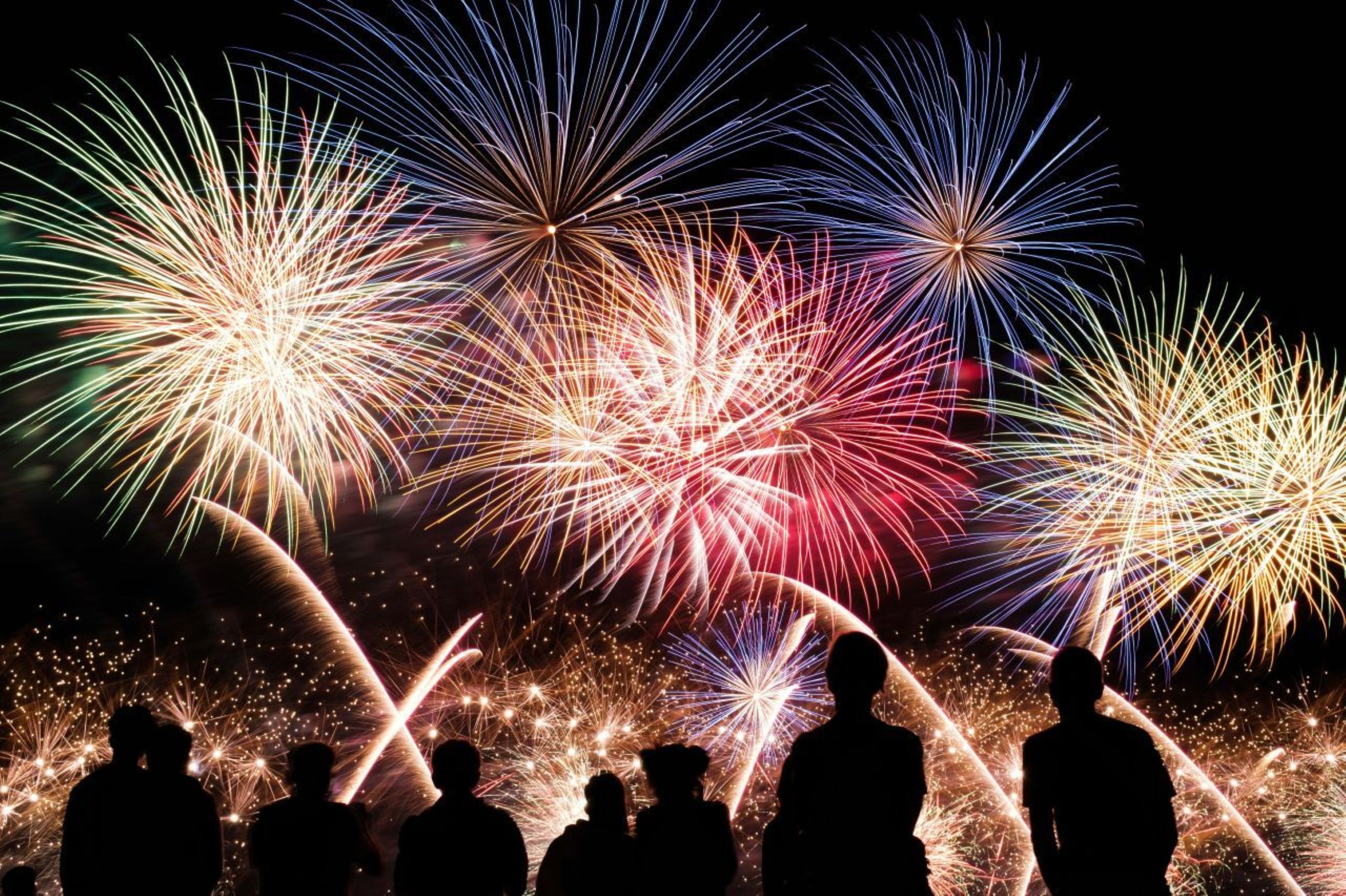 Group of people standing watching a firework display