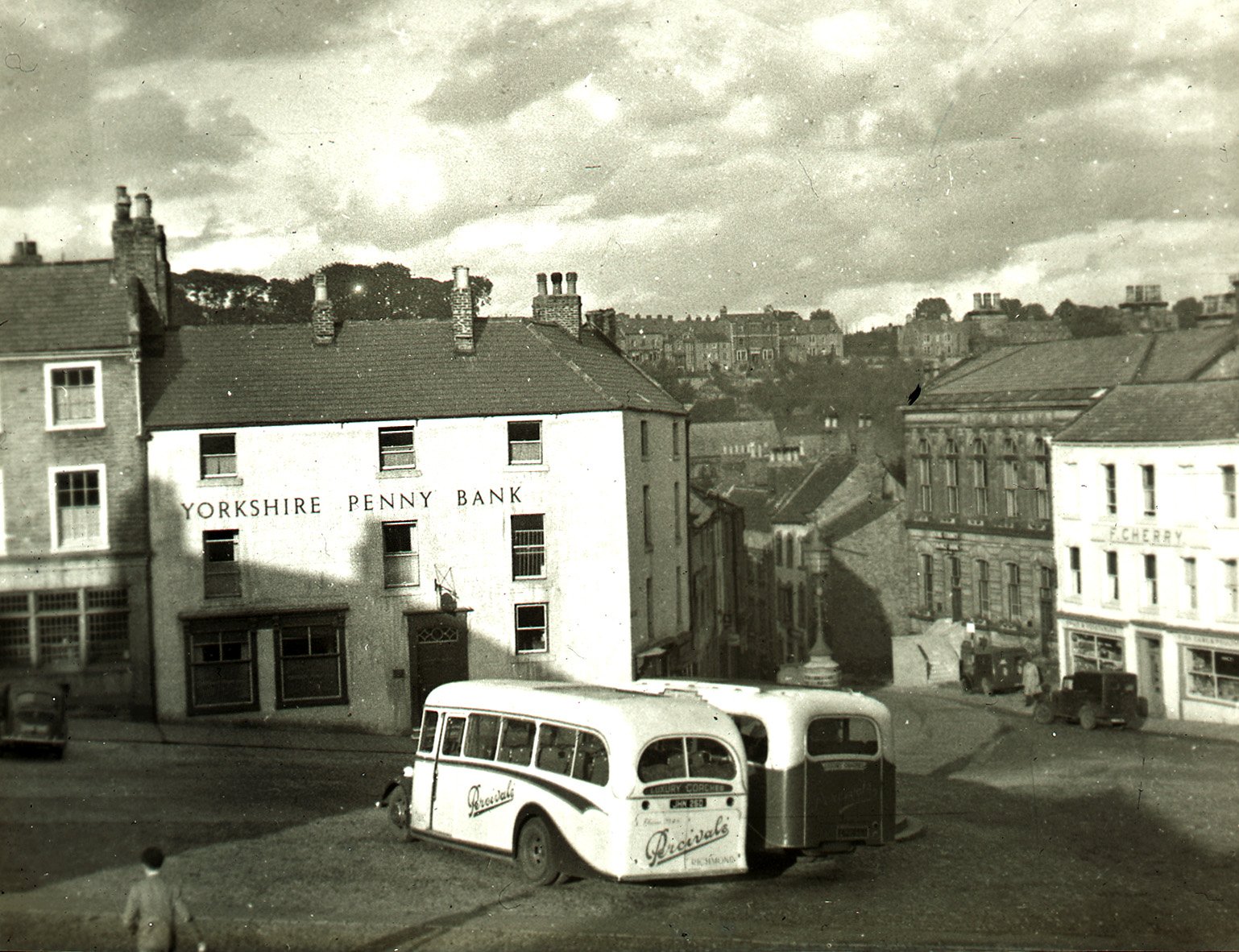Yorkshire Penny Bank with two Percival’s Coaches parked in the Market Place, Richmond, in October 1948. Image taken by the Bradford Photographic Society.