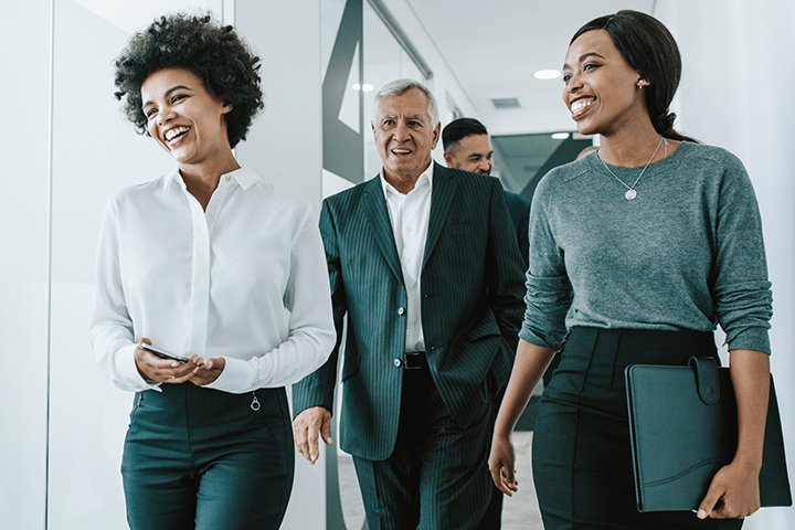 People walking and talking in office.
